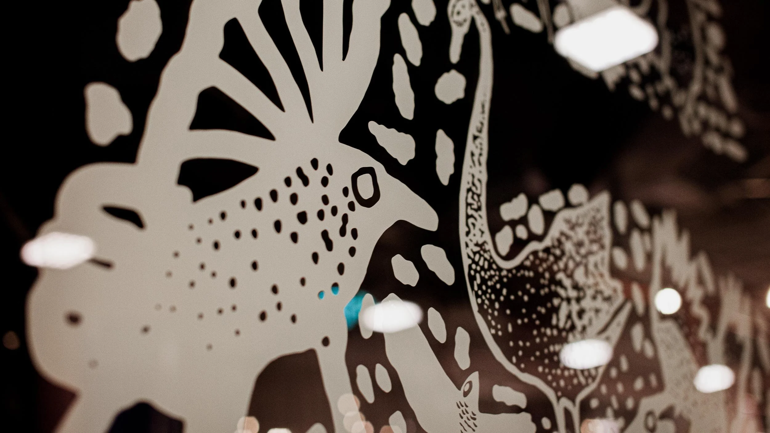 Closeup of two of the birds in the decal on the Byrdi window drawn loosely with lines and dots.