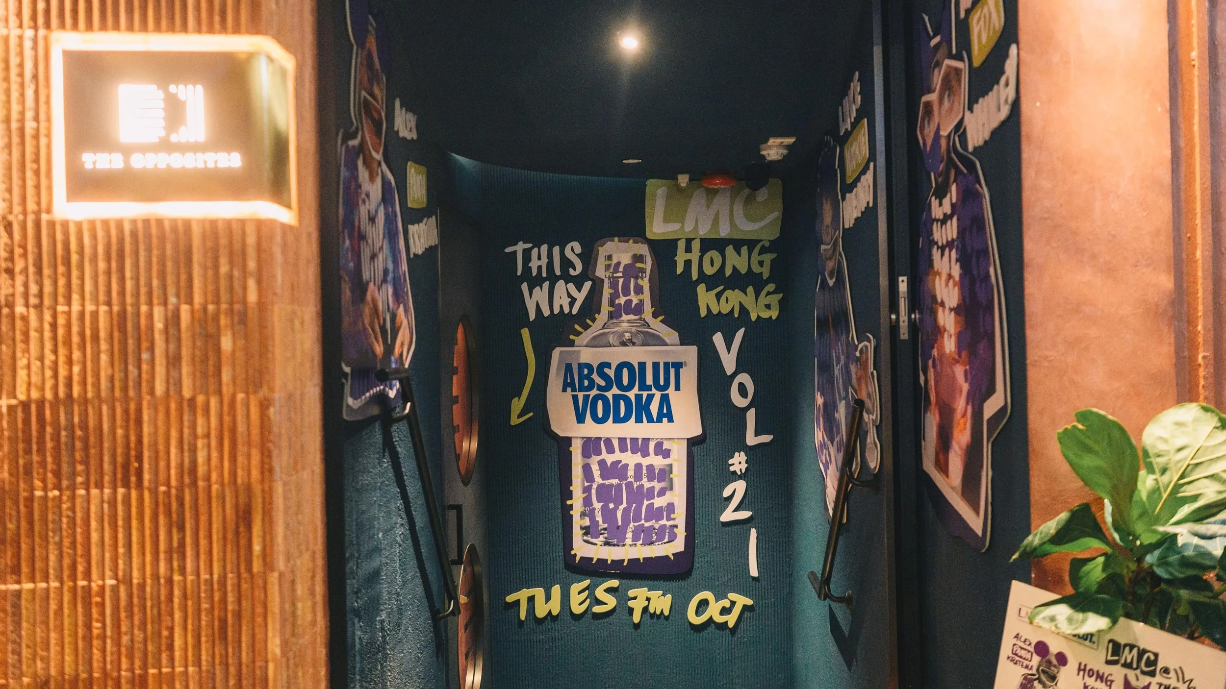 Stairwell of The Opposites bar in Hong Kong featuring cut-out graphics promoting LMC Vol #21: Absolut Vodka bottle surrounded by hand-drawn type (front) and portraits of Alex Kratena, Luke Whearty and Matt Whiley in a collage style (sides).