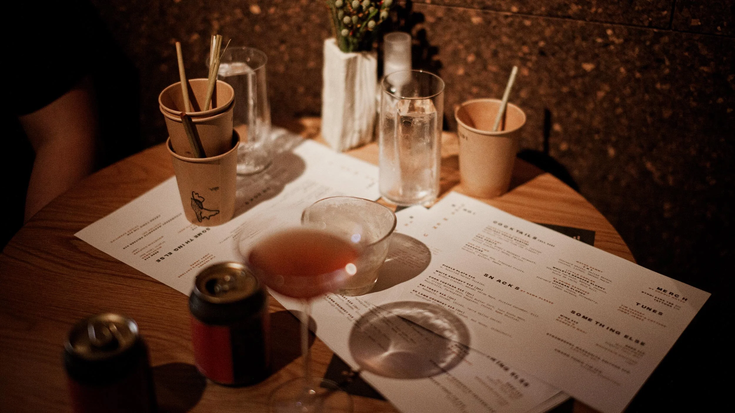 Menus and empty drink glasses sitting on a wooden table.