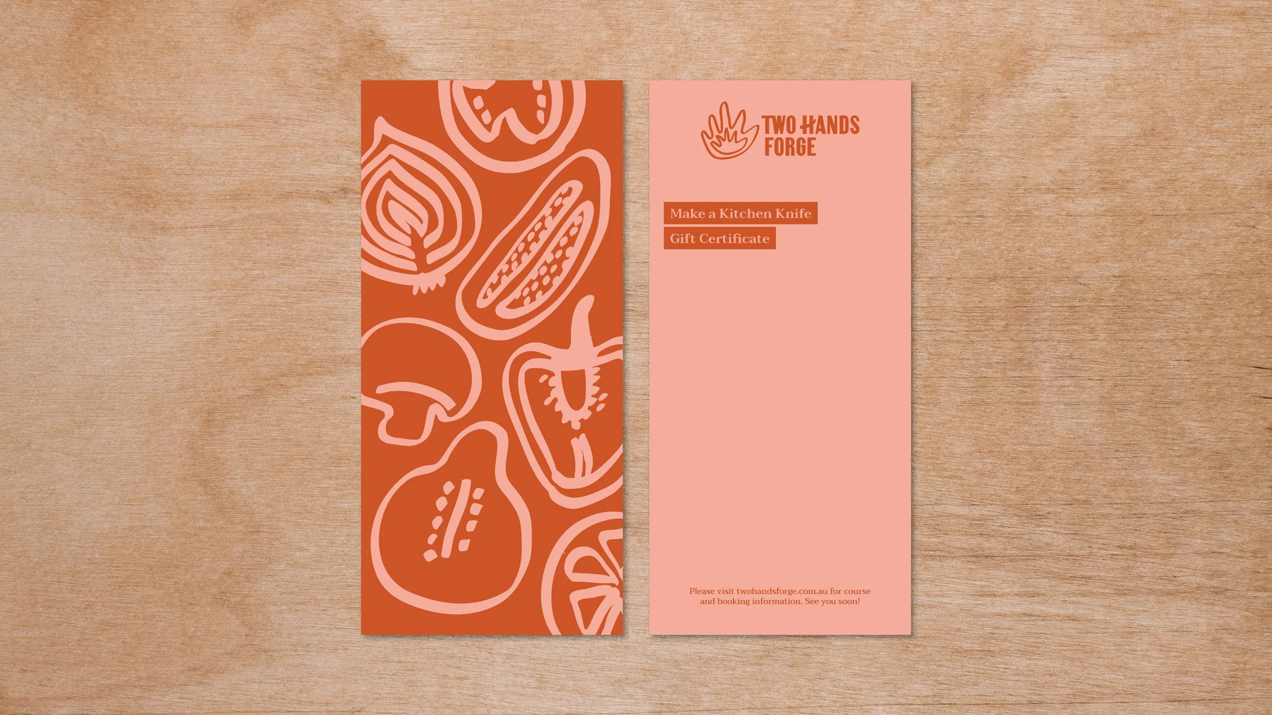Front and back of Two Hands Forge gift vouchers sitting on a plywood background showing illustrations on one side and logo on reverse.