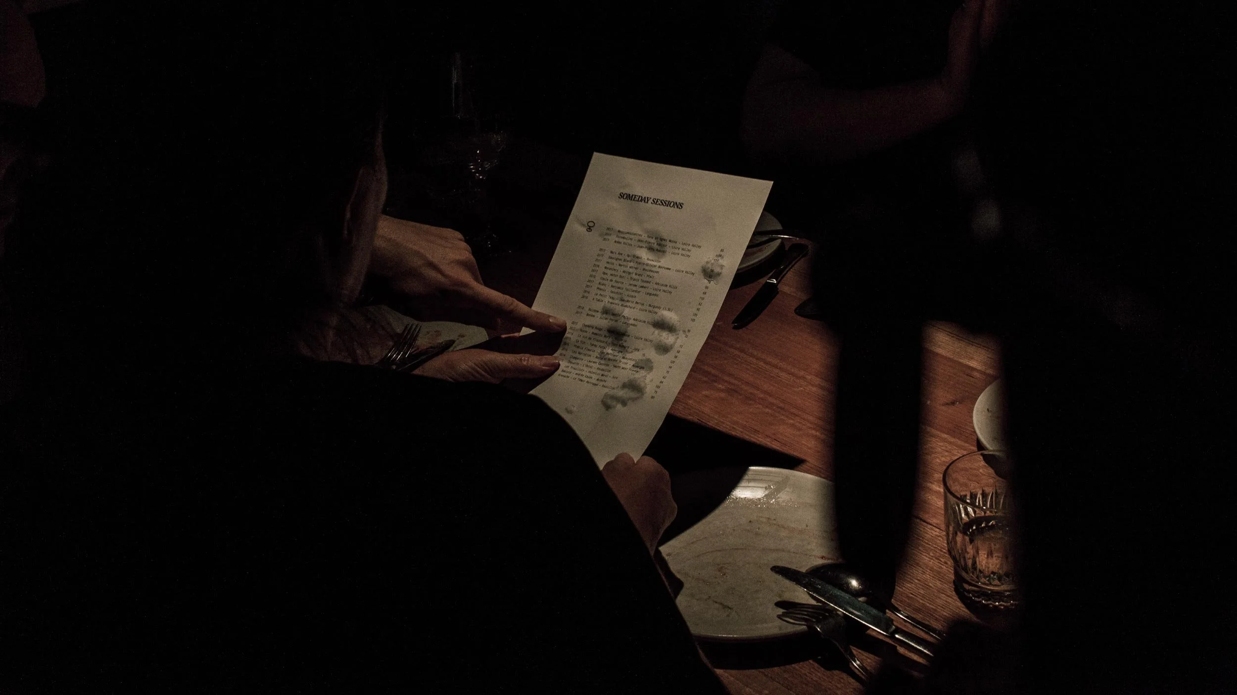 Rear view of somebody holding a Someday Sessions wine menu at Osteria Ilaria in Melbourne.