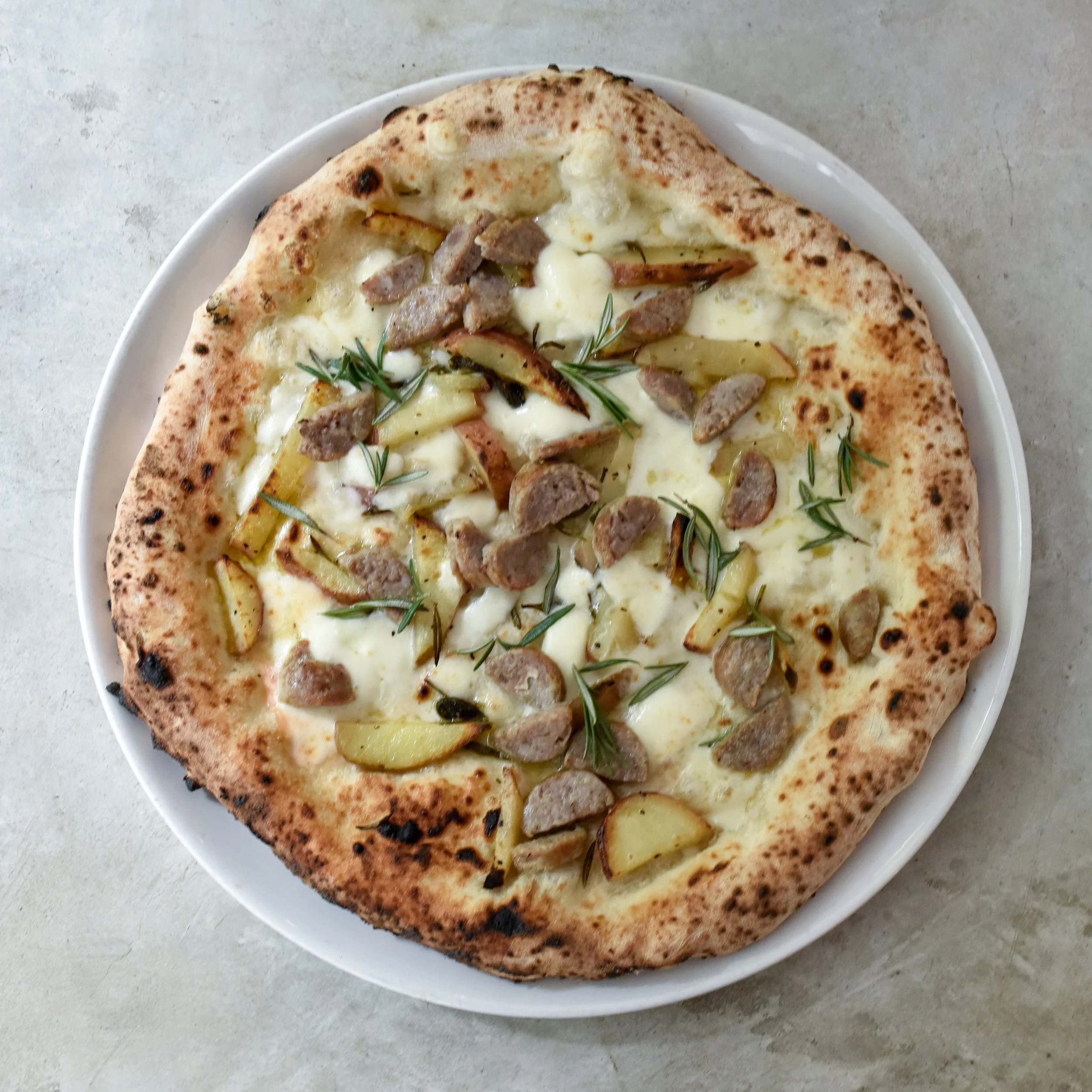 Woodired Pizza with sausage and potatoes