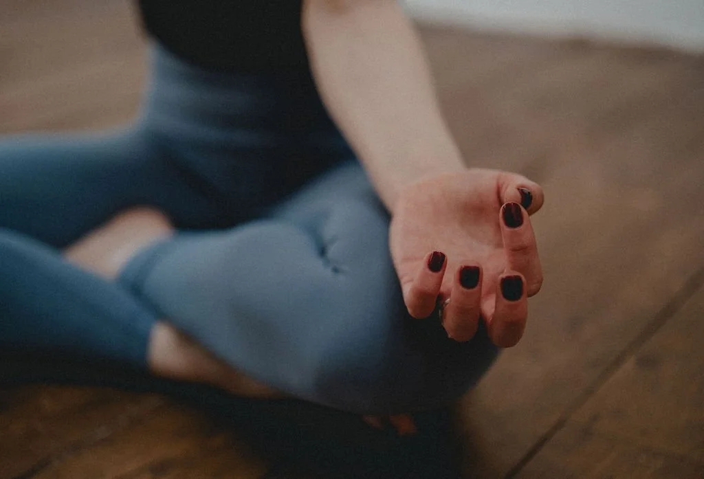 Cally Youdell, private yoga teacher in Hale Altrincham sits in yoga pose with mudra