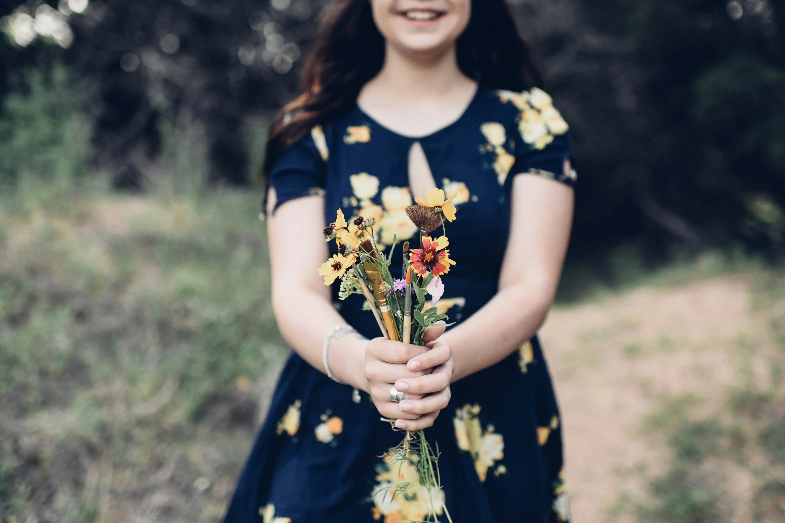 senior+girl+holding+paint+brushes+and+wildflowers.jpeg