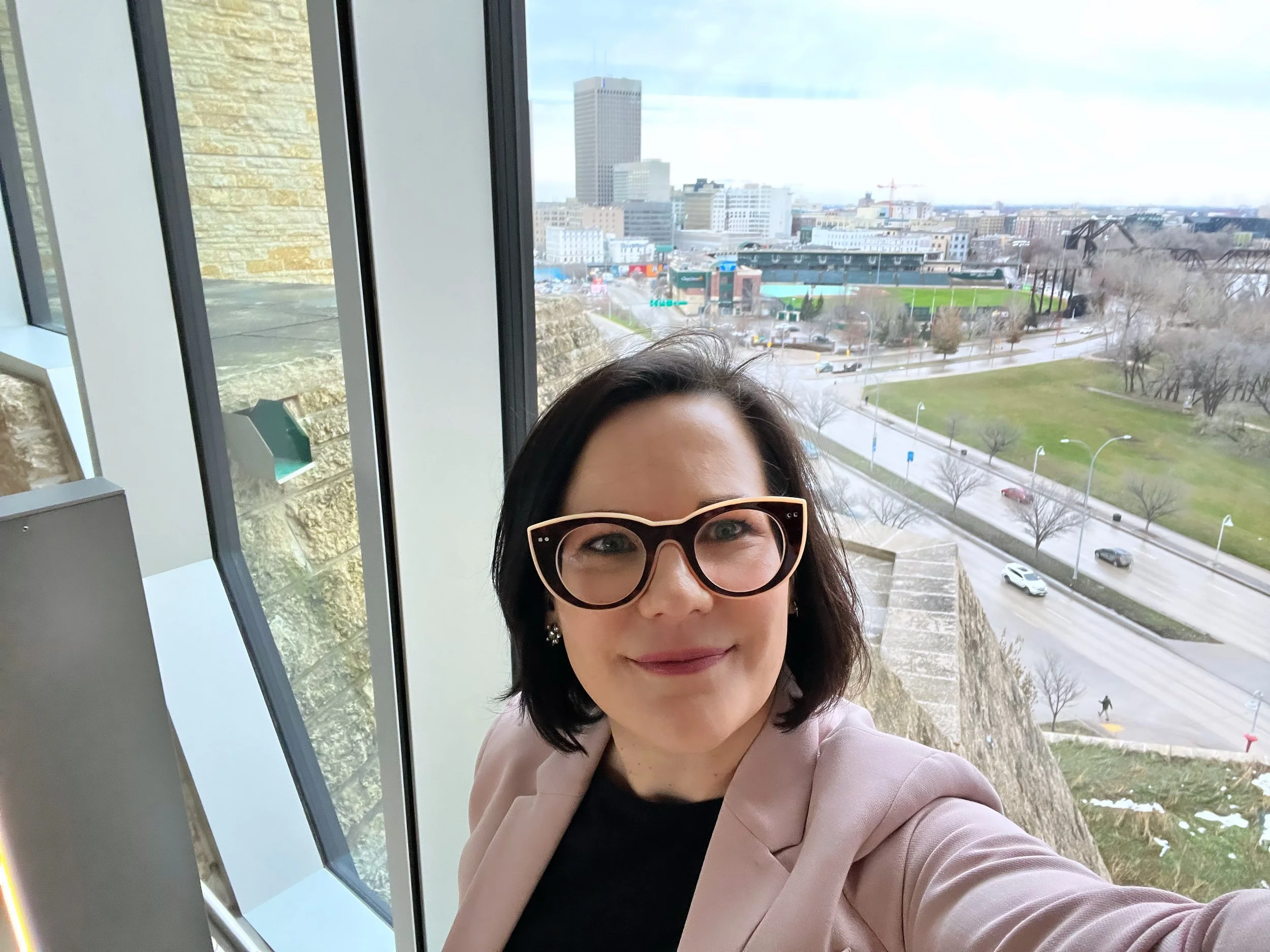 Susan standing in front of a window at the Canadian Museum for Human Rights