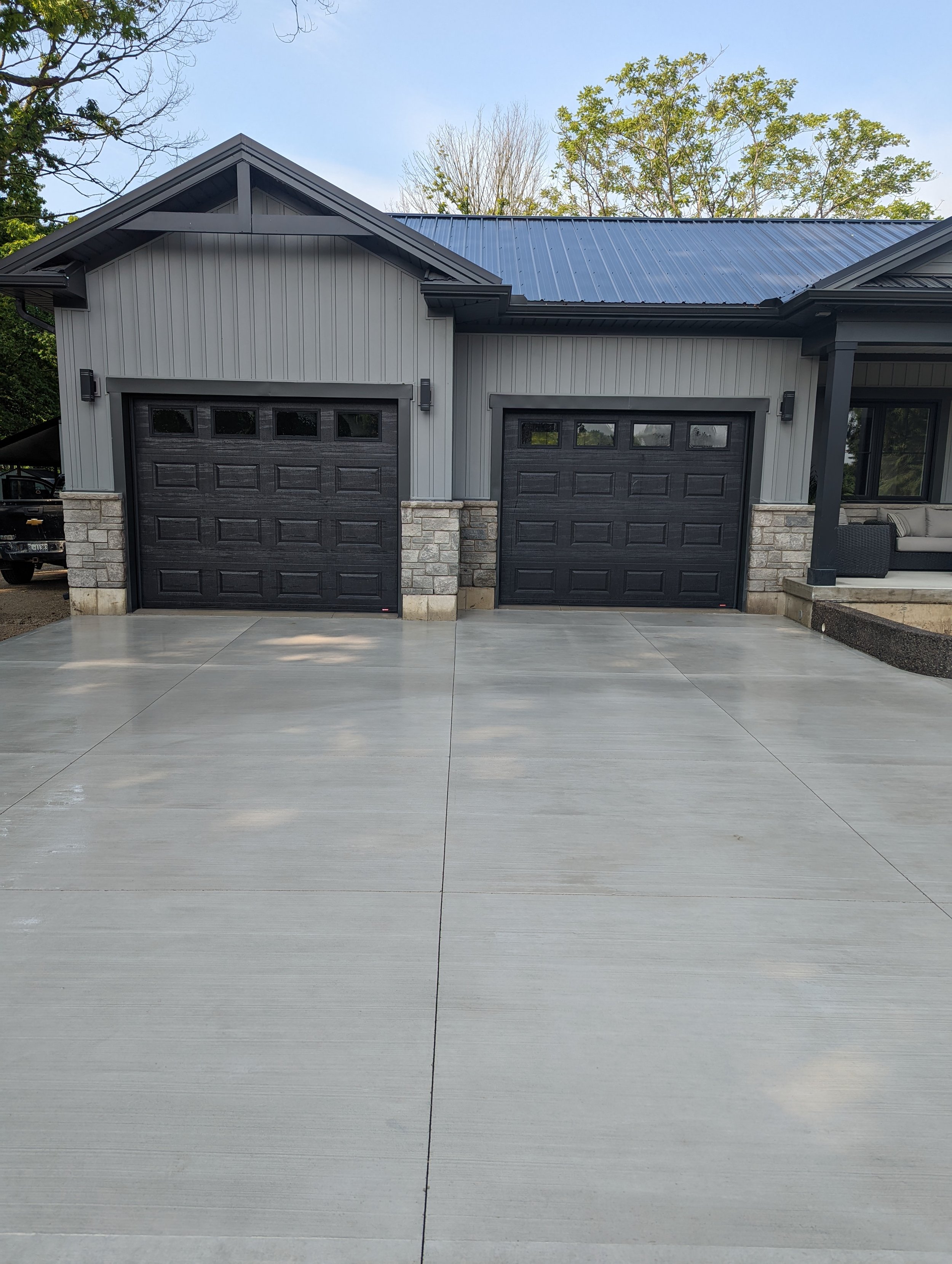 Modern house with two garage doors and a wide concrete driveway