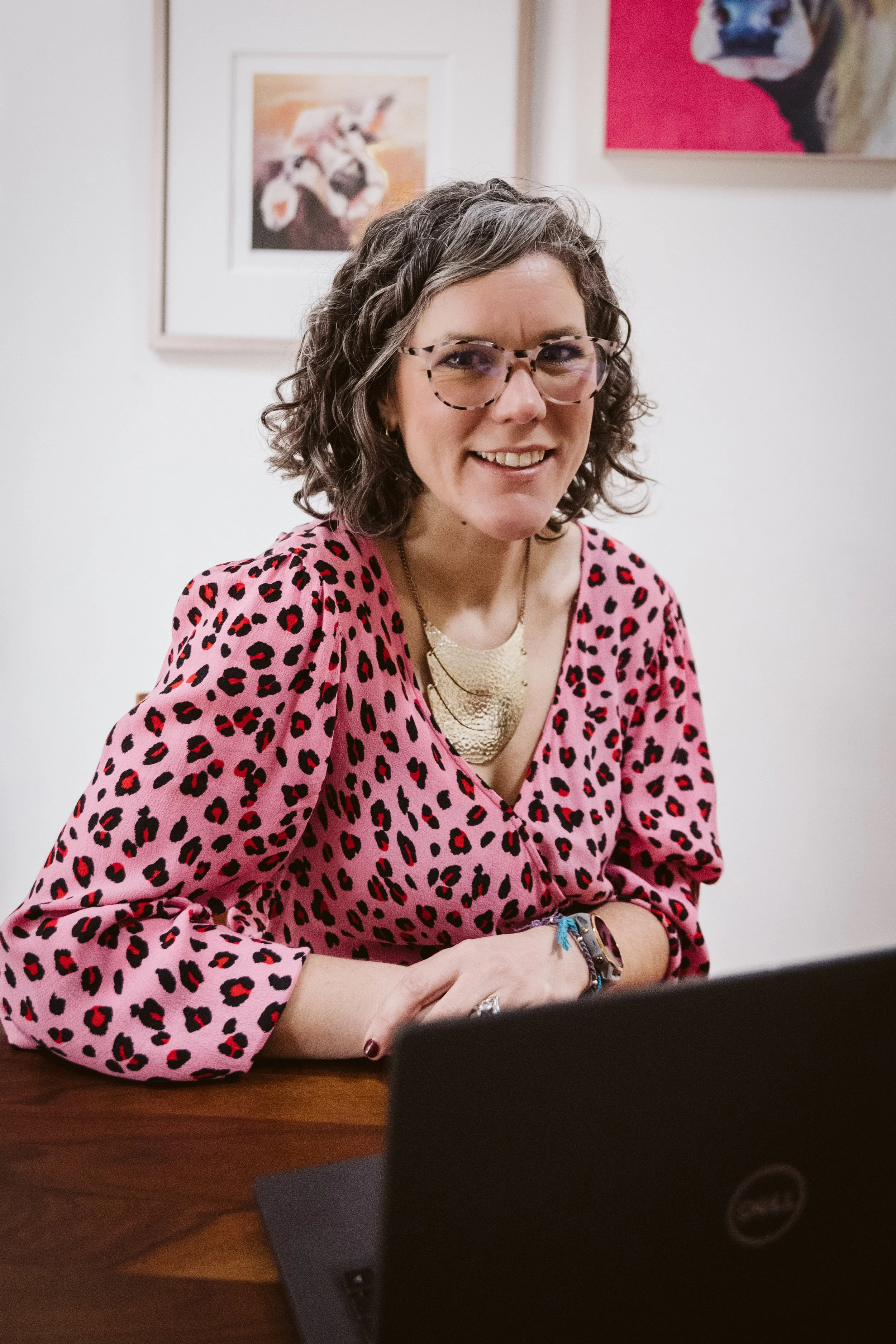 Laura Walker of The Jobshare Revolution sits smiling behind a laptop