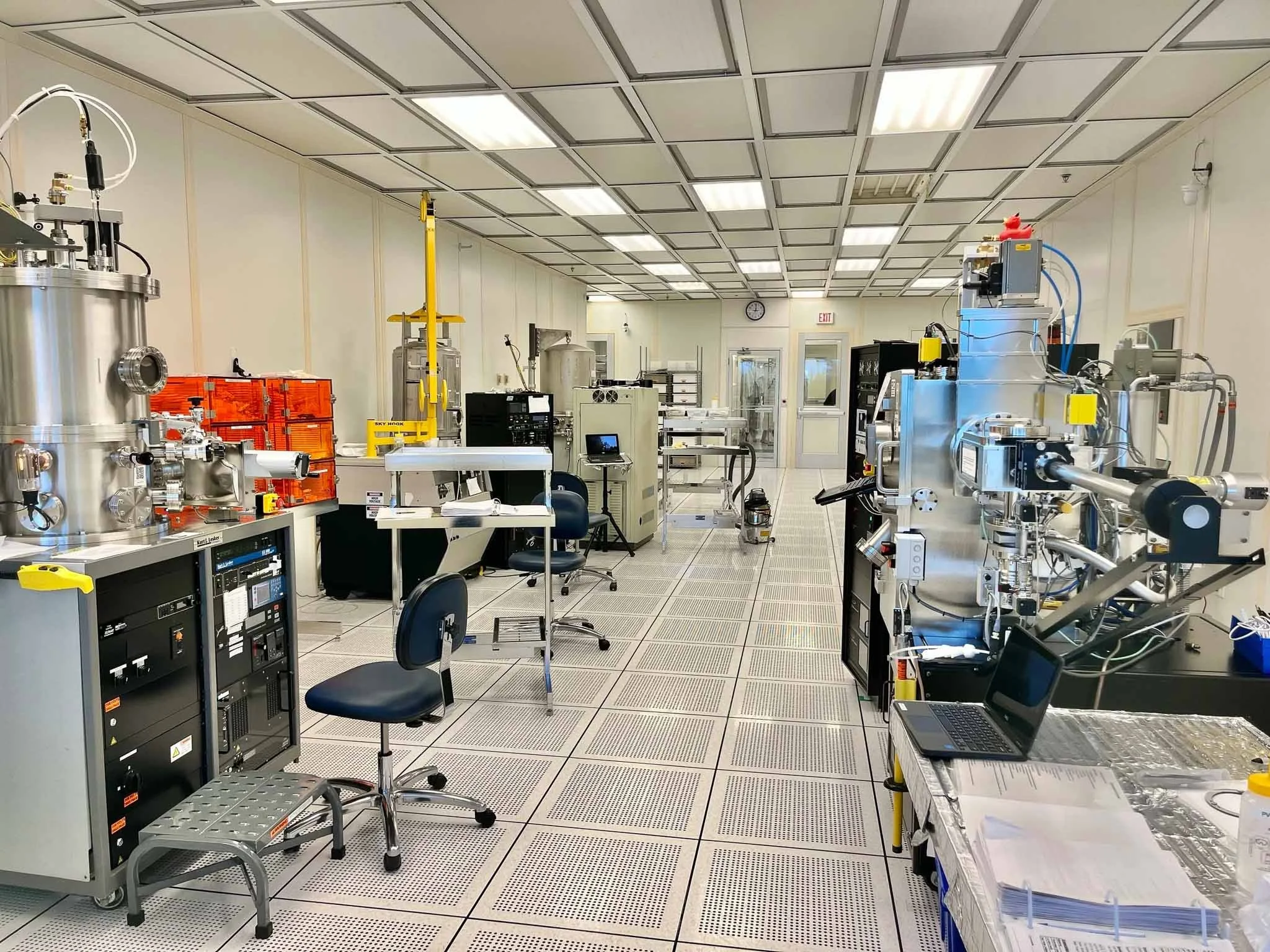 A clean scientific laboratory with various scientific instruments, computer equipment, and workstations.
