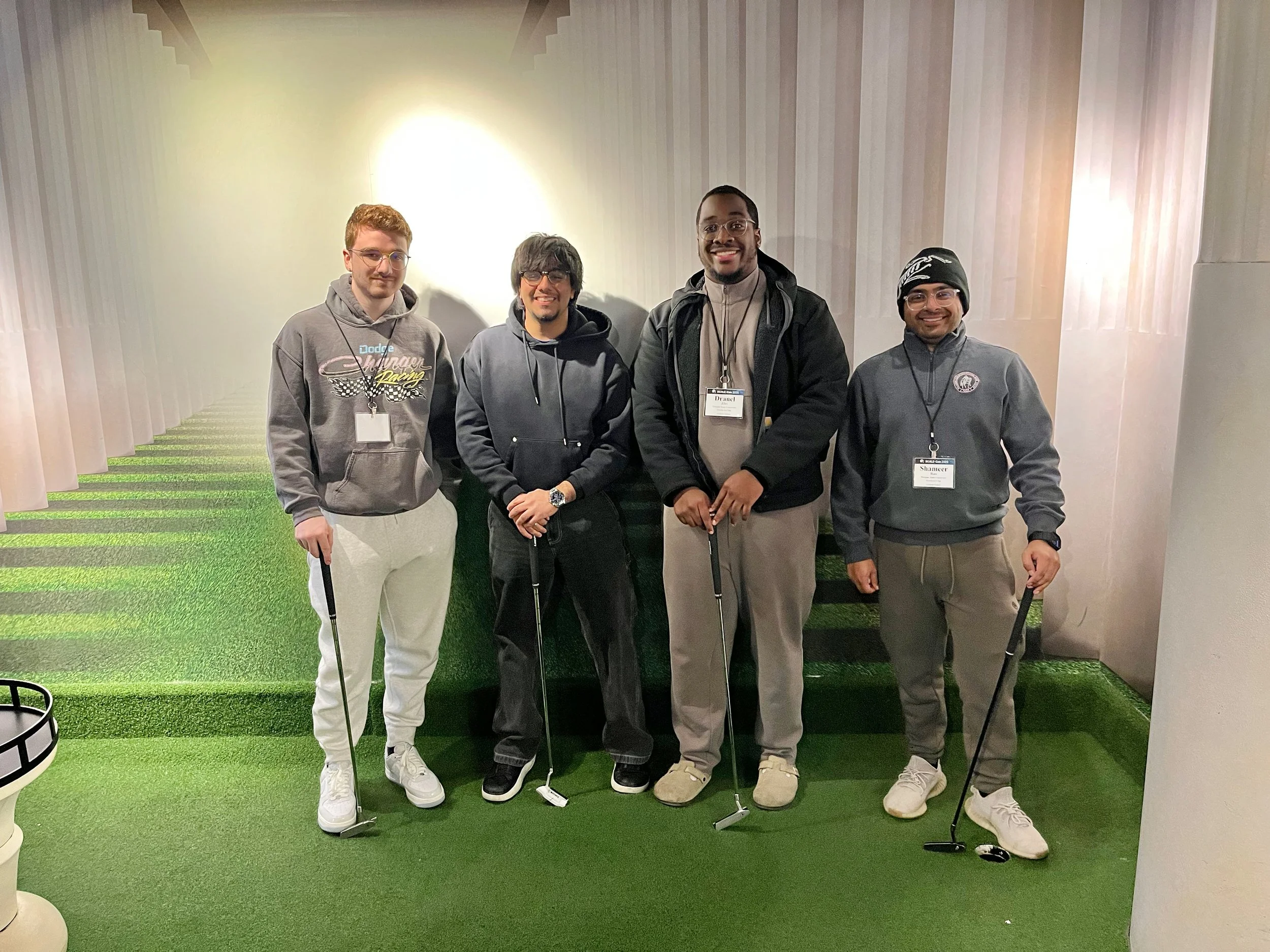 four students with golf clubs