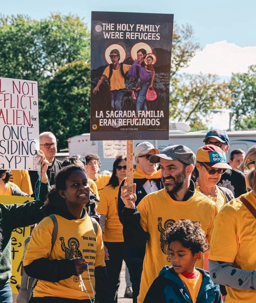 CSPL activists holding a sign that reads "The Holy Family were refugees" at a Eucharistic Procession to Broadview Detention Center for the religious freedom of immigrants