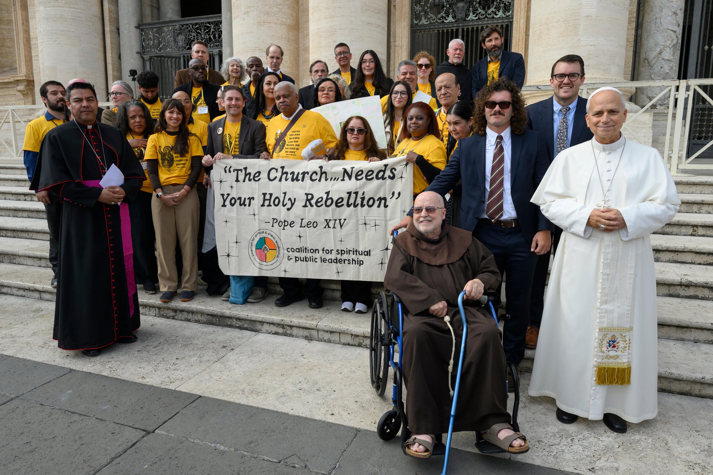 The CSPL delegation poses with Pope Leo on the Vatican steps, holding a banner that reads, "The Church Needs Your Holy Rebellion."