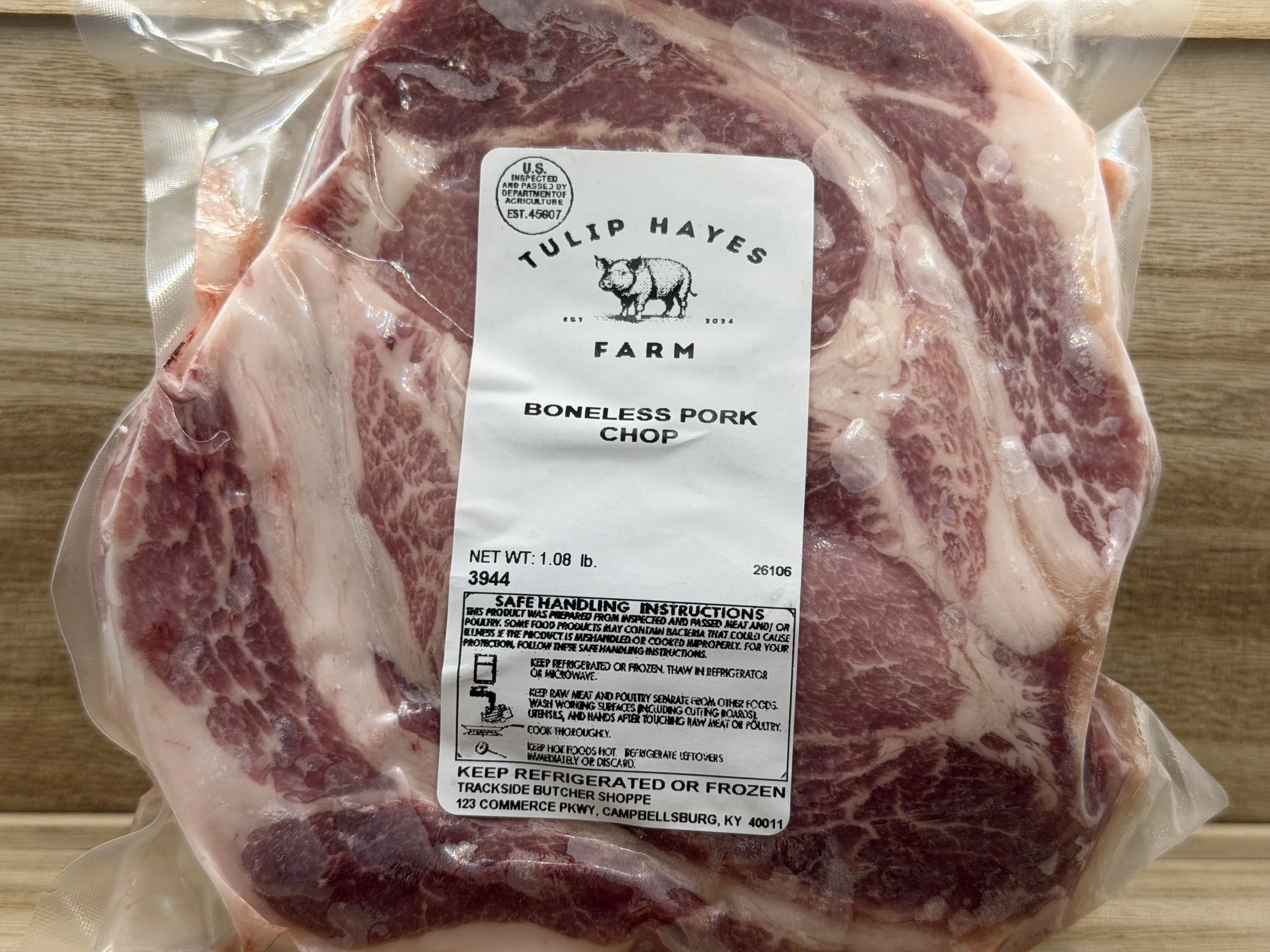 Package of boneless pork chop from Tulip Hayes Farm with a white label that includes a pig logo and handling instructions.