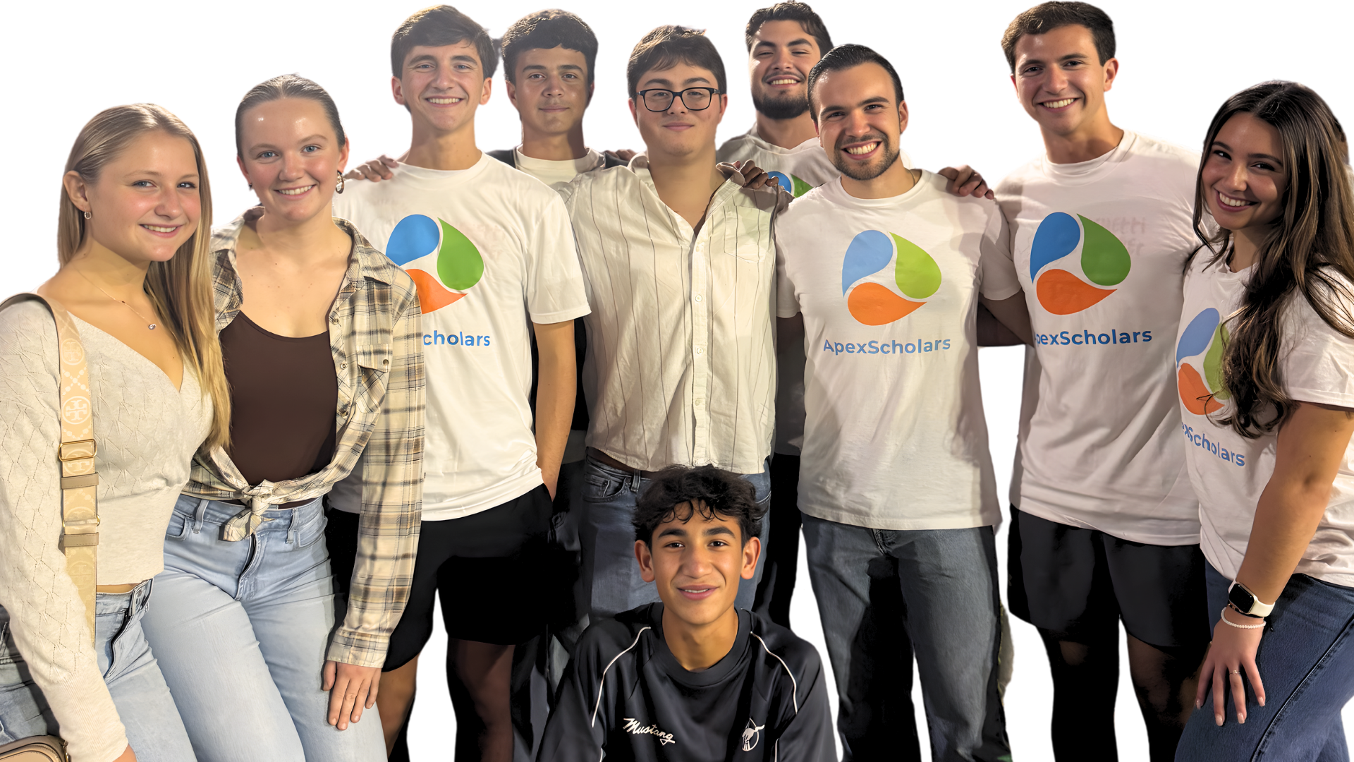 A group of diverse young people, some wearing Apex Scholars t-shirts, smiling and standing together.
