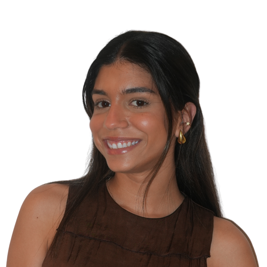 A young woman with dark hair, wearing a cream blazer and black top, smiling softly against a white background. Her name is Keren Ariz