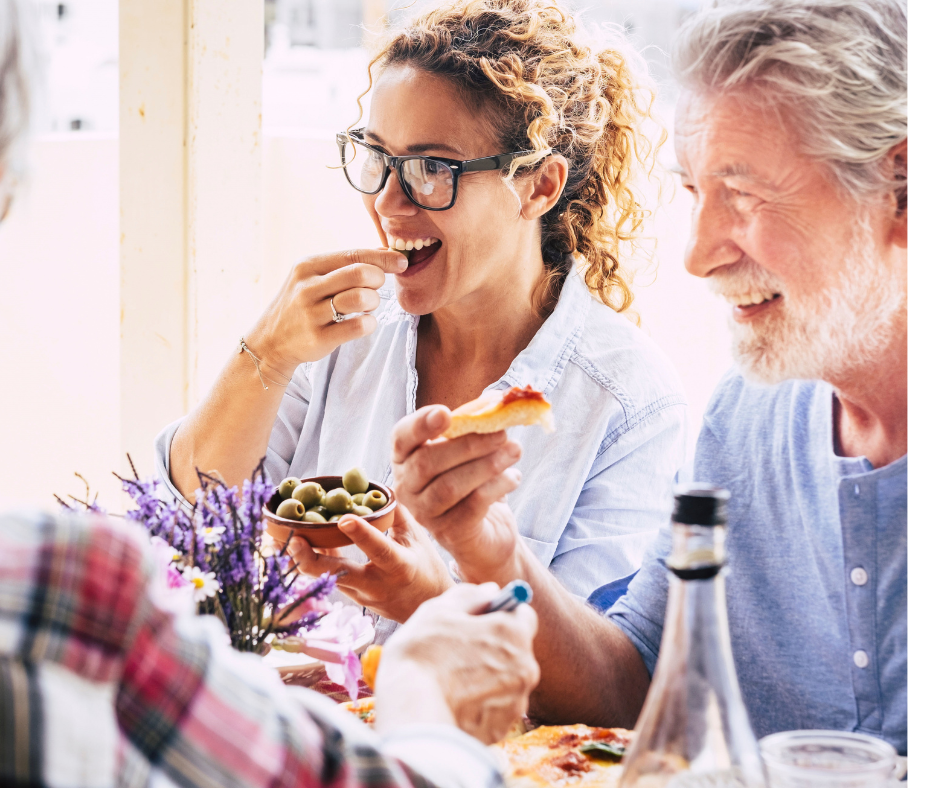 a happy couple eats olives and bread with friends