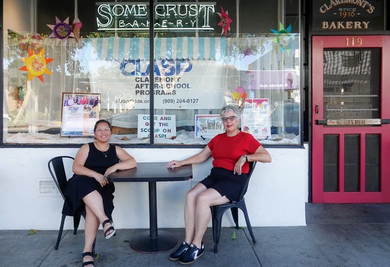 Tutor Coordinator Grace Aguinaldo and Board Vice-President Carol-Lee Marshall at Some Crust Bakery after installing a display window promoting volunteering with CLASP for the entire month of August.