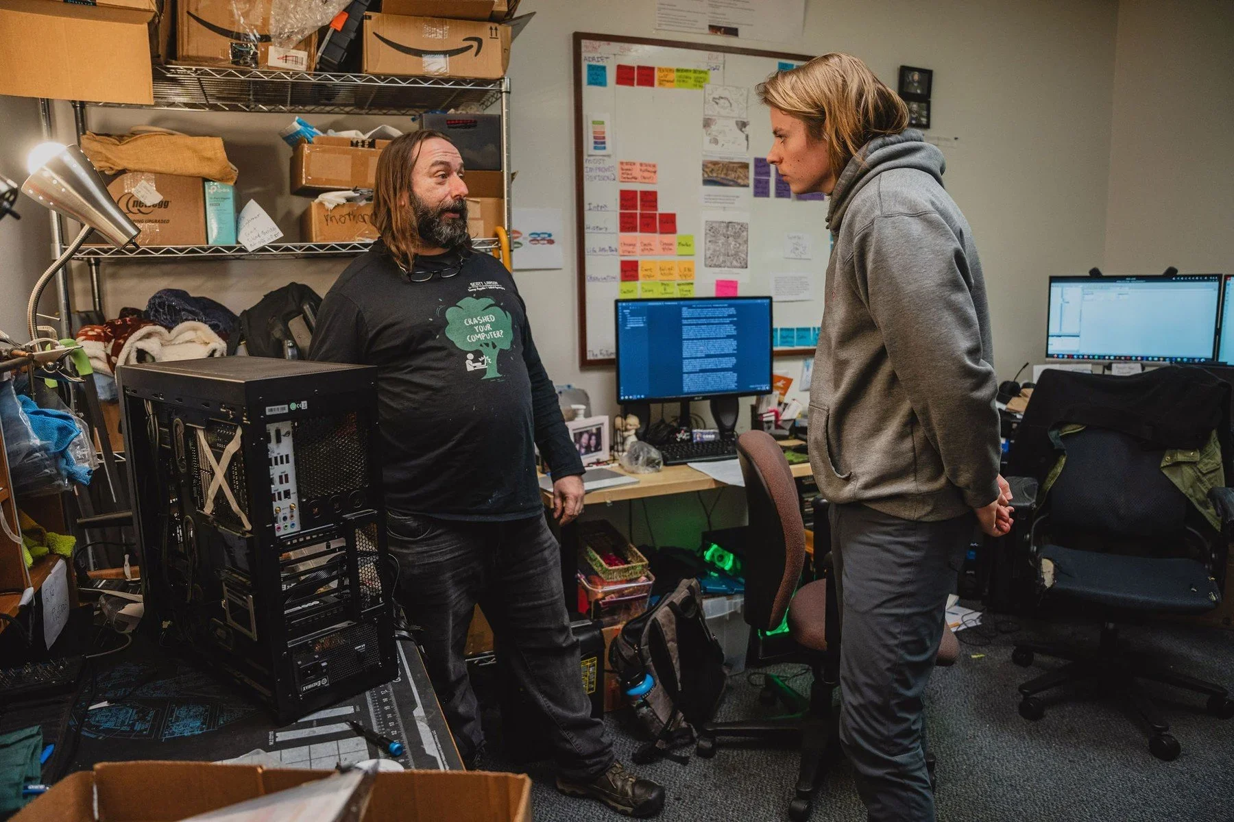 A student and mentor discussing computer hardware in a workshop