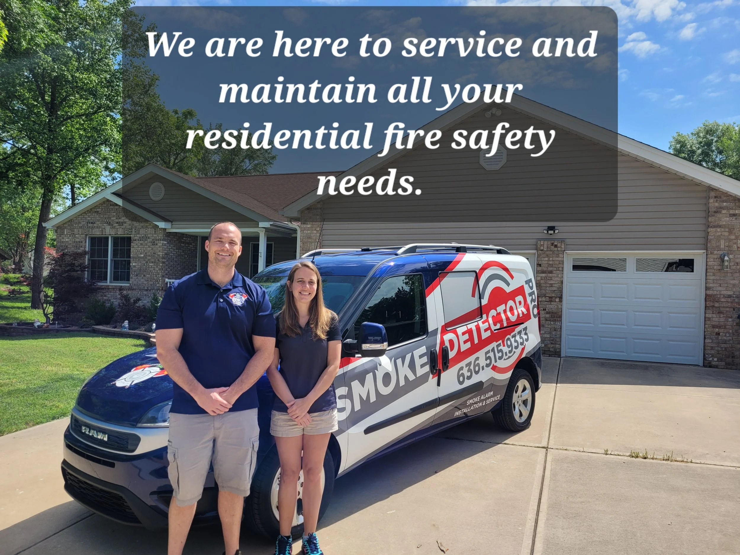 A man and woman standing in front of a service van with the logo and contact information for a smoke detector installation and service company. The house behind them has a brick and siding exterior, a driveway, and a garage. The scene is sunny with a blue sky and trees in the background.