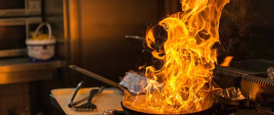 Pan high flames in a kitchen setting,  needing a smoke detector Pro fire blanket