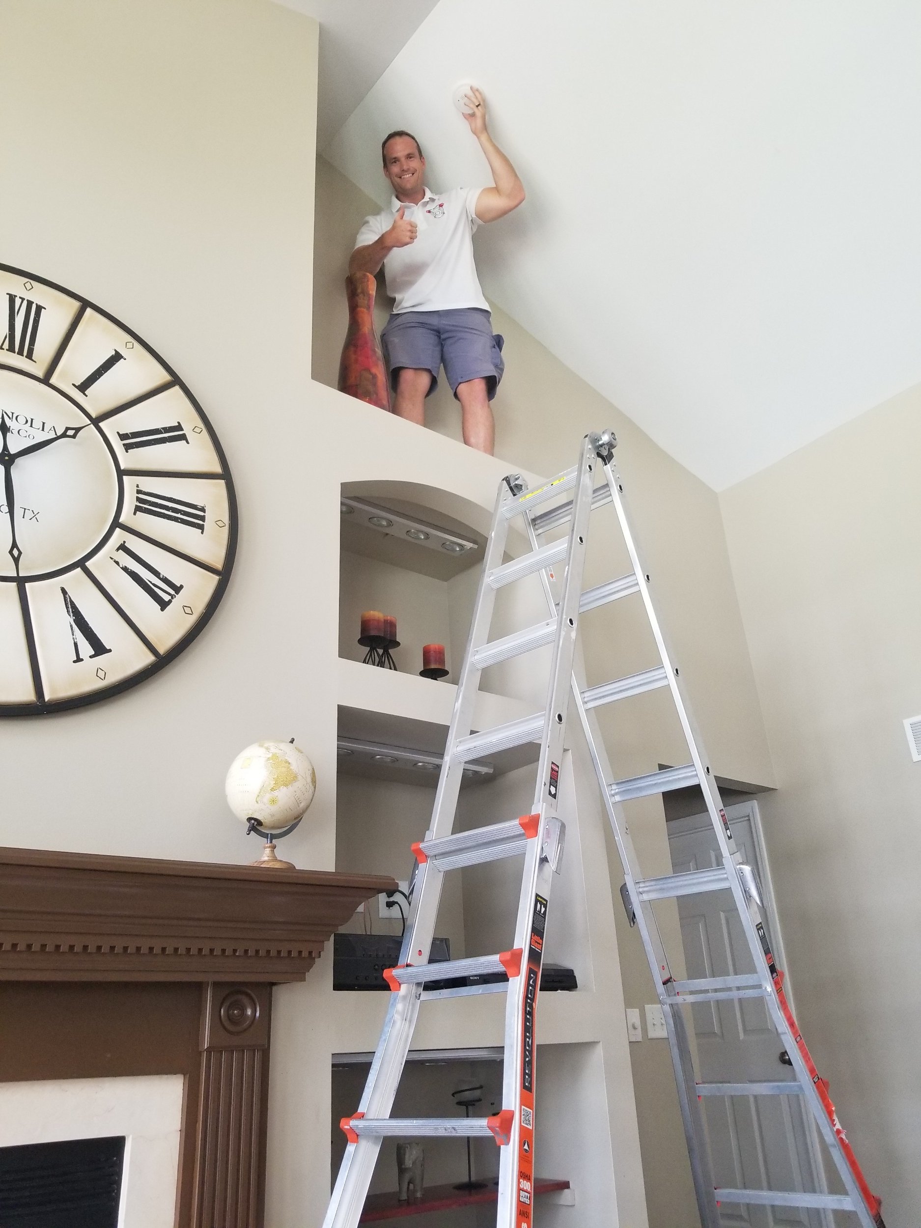 Happy customer thumbs up with high ceiling smoke alarm replaced.