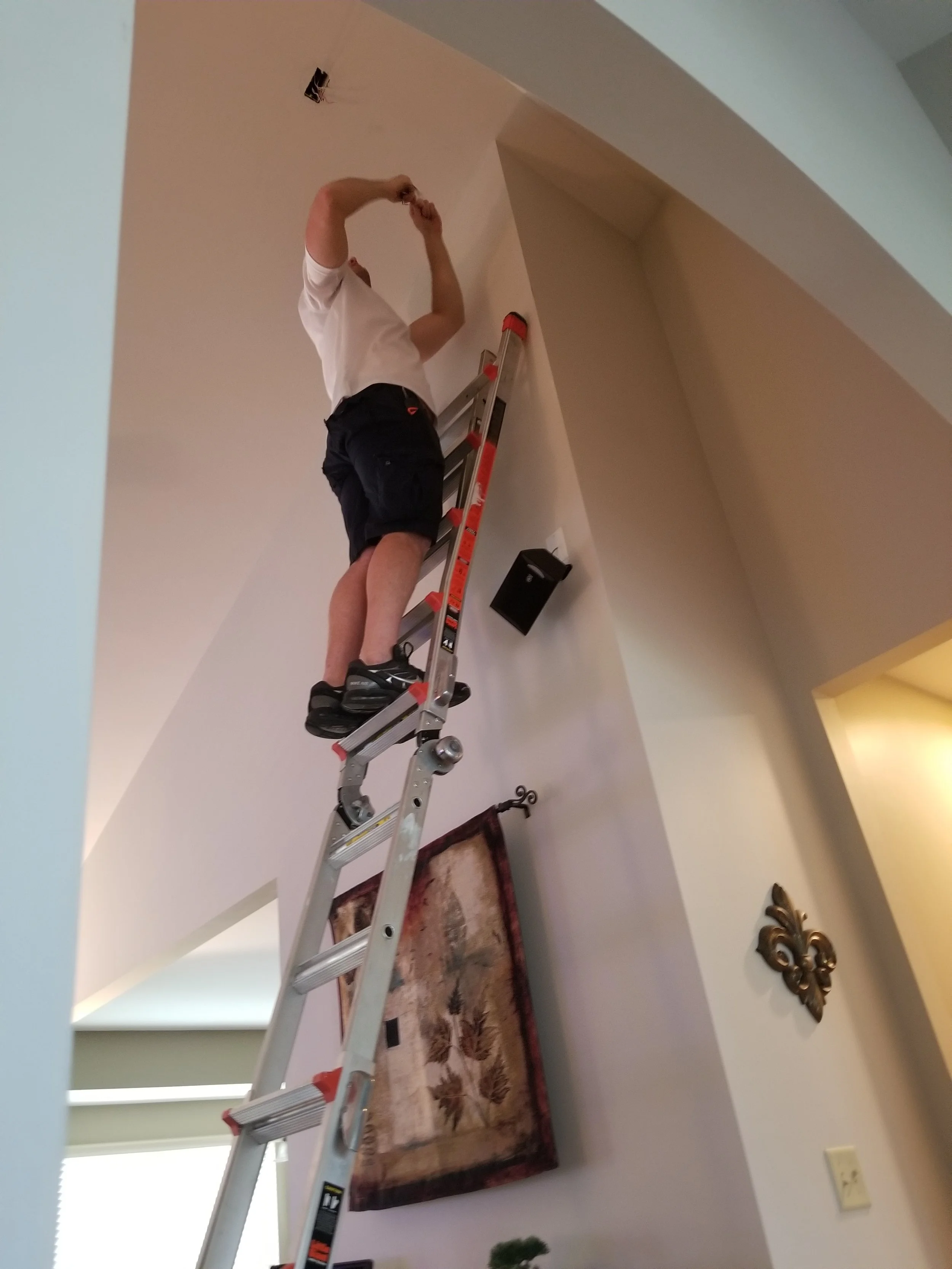 Service technician with Smoke Detector Pro replacing an old fire alarm.