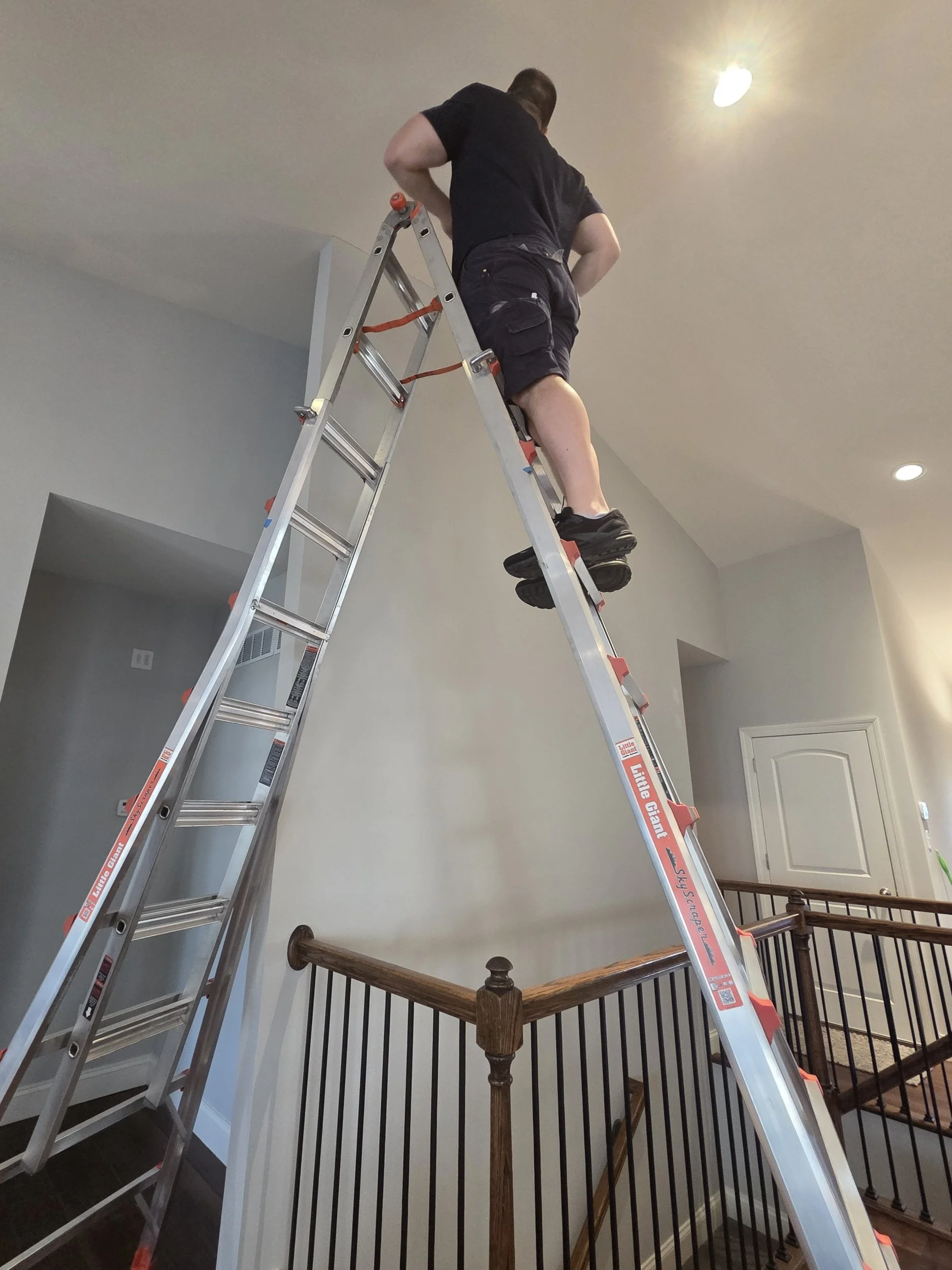 Smoke Detector Pro in a local home on a high ladder replacing smoke alarms
