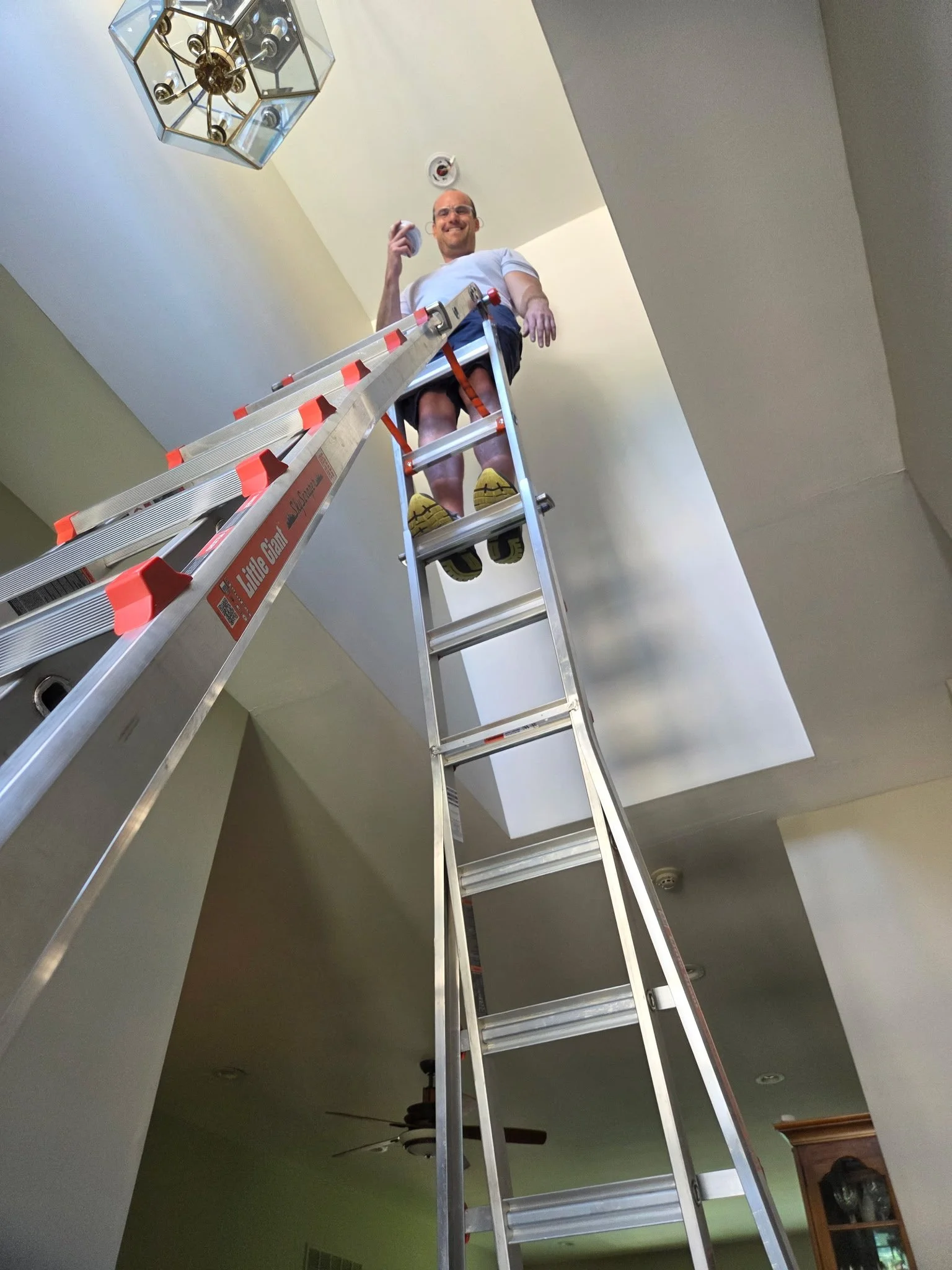 irefighter inspecting a chirping smoke detector inside a residential home