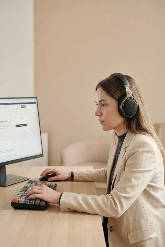 A lady wearing headphones to simulate the experience of someone who uses VoiceOver to access their computer screen
