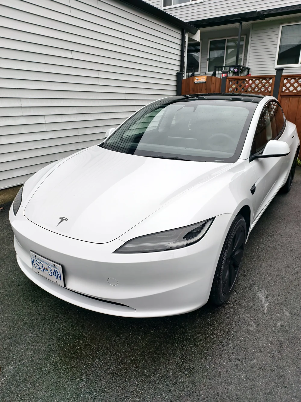 White Tesla Model 3 on a residential driveway