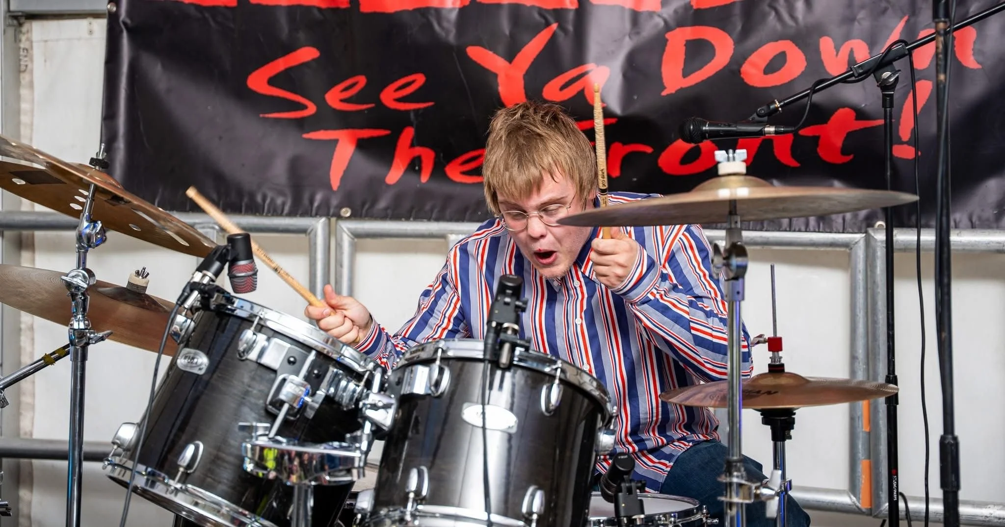Denny Keil drumming on stage with Monumental both playing guitar