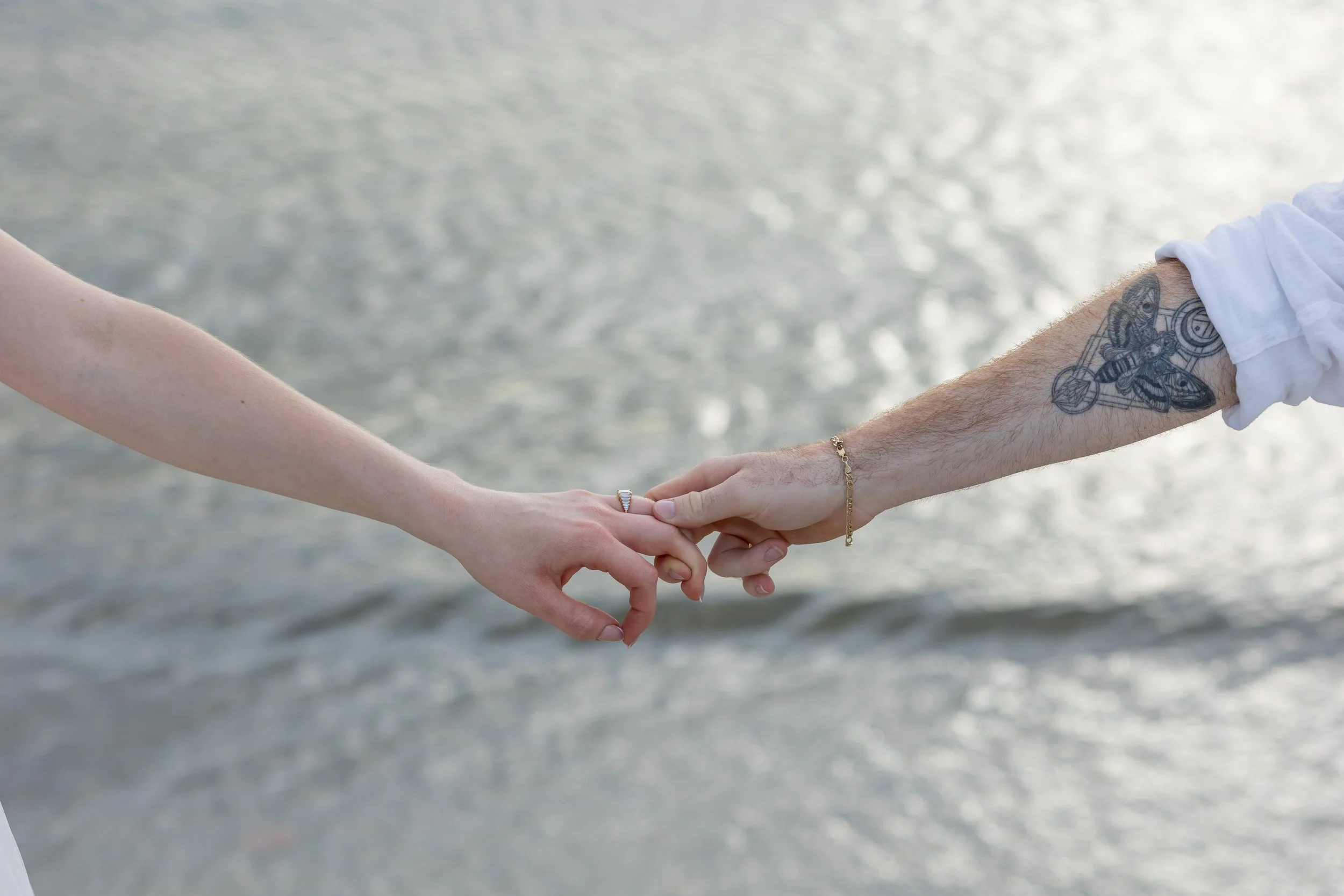 Bride and groom holding hands across the shore at their Florida beach elopement – a romantic moment captured just before golden hour.