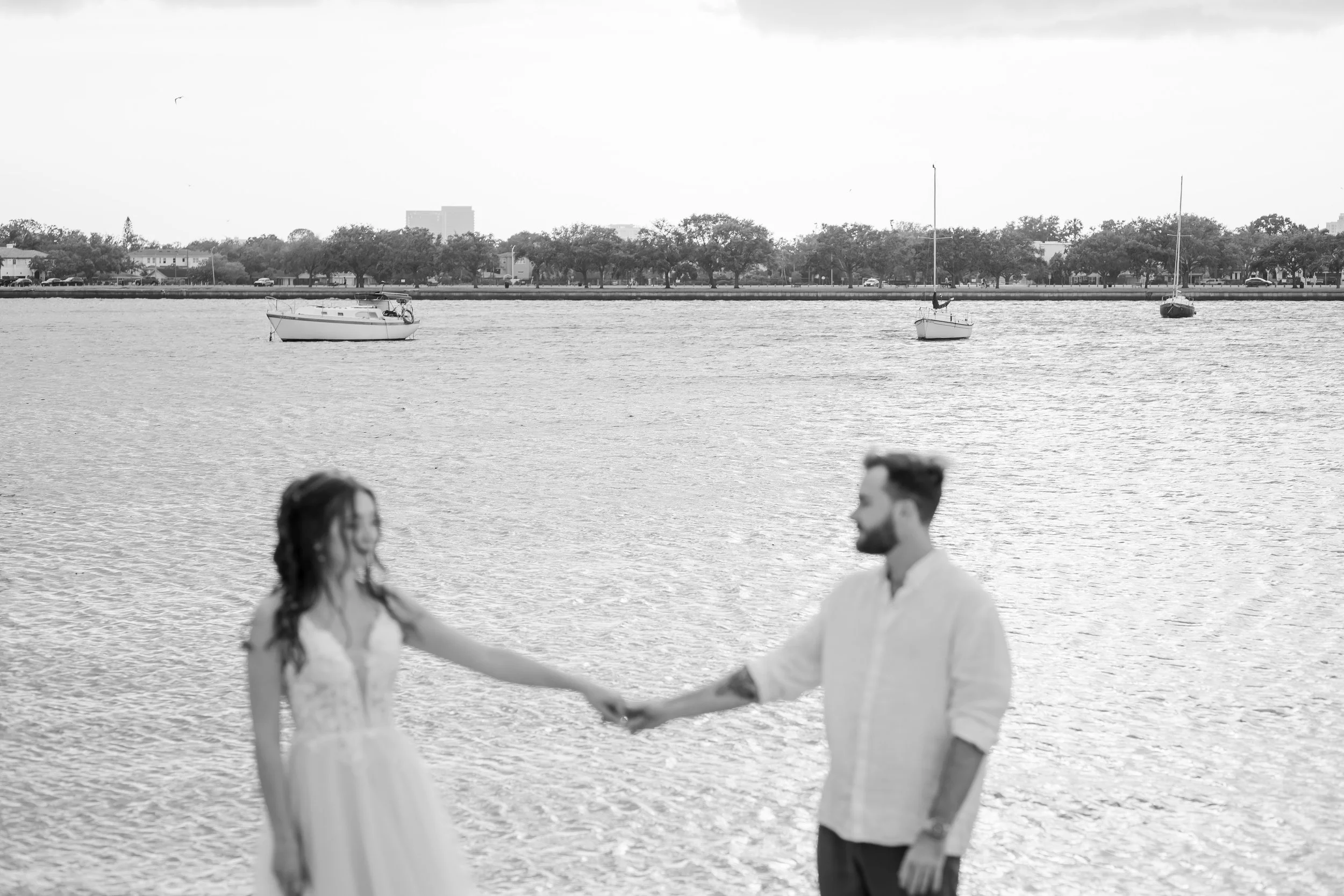 Timeless black and white photo of bride and groom on the beach in Clearwater, FL – candid and heartfelt wedding photography.