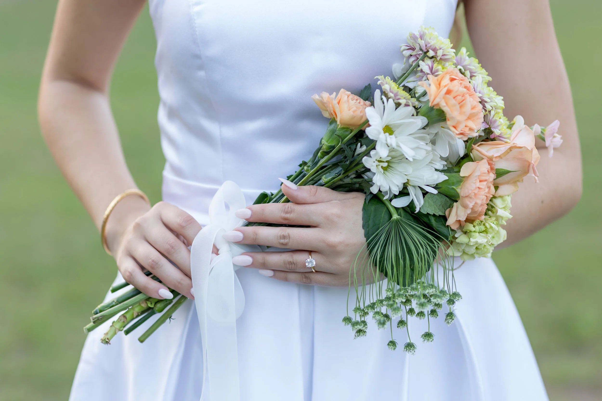 Classic bridal bouquet of white and peach florals captured in a detailed close-up shot
