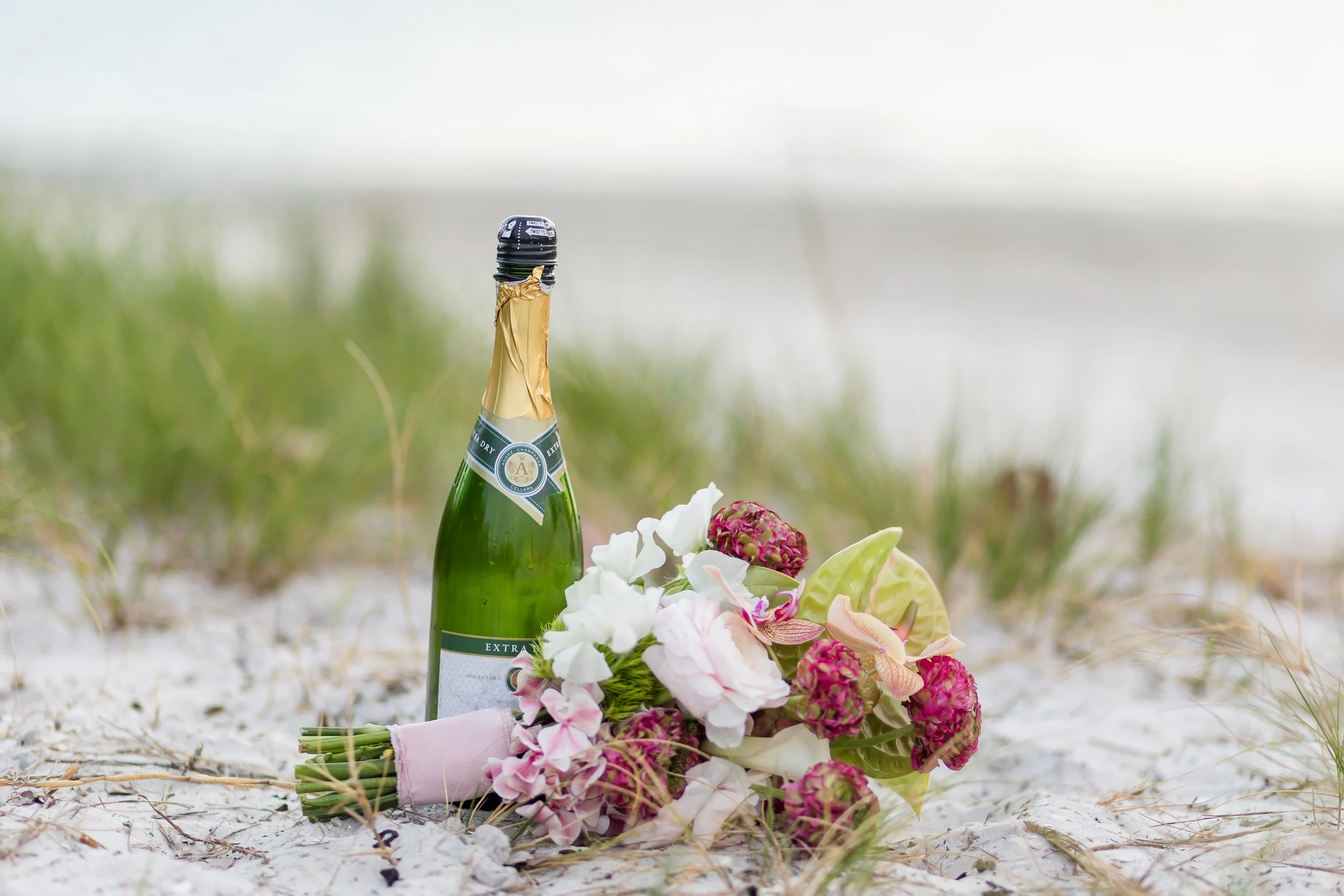 Beachside wedding detail with bouquet and champagne – the perfect celebration setup for an intimate Florida coastal ceremony.