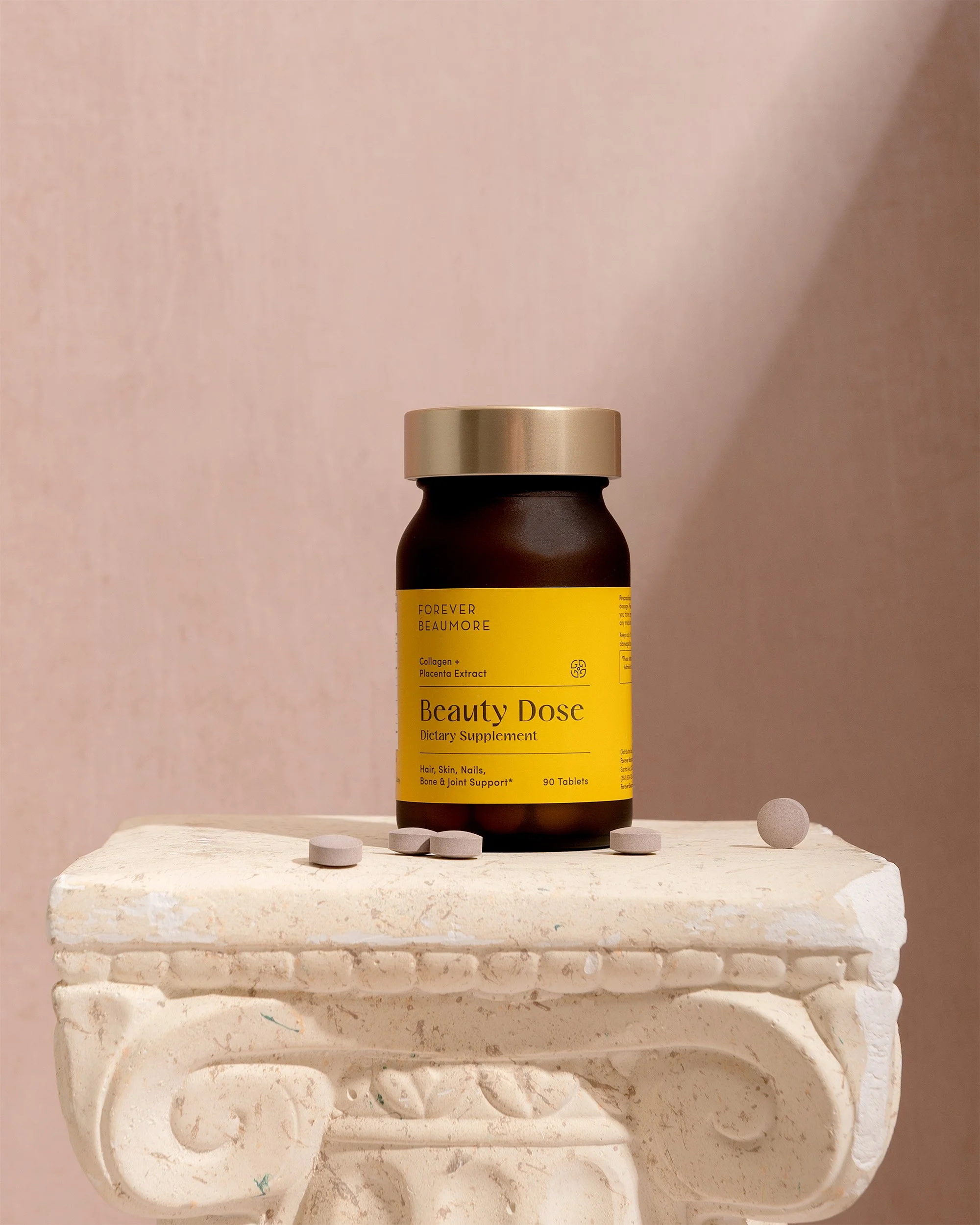 Still life product photography of a supplement bottle sitting on a greek column with a shadow on the left side of frame. Shot in studio.