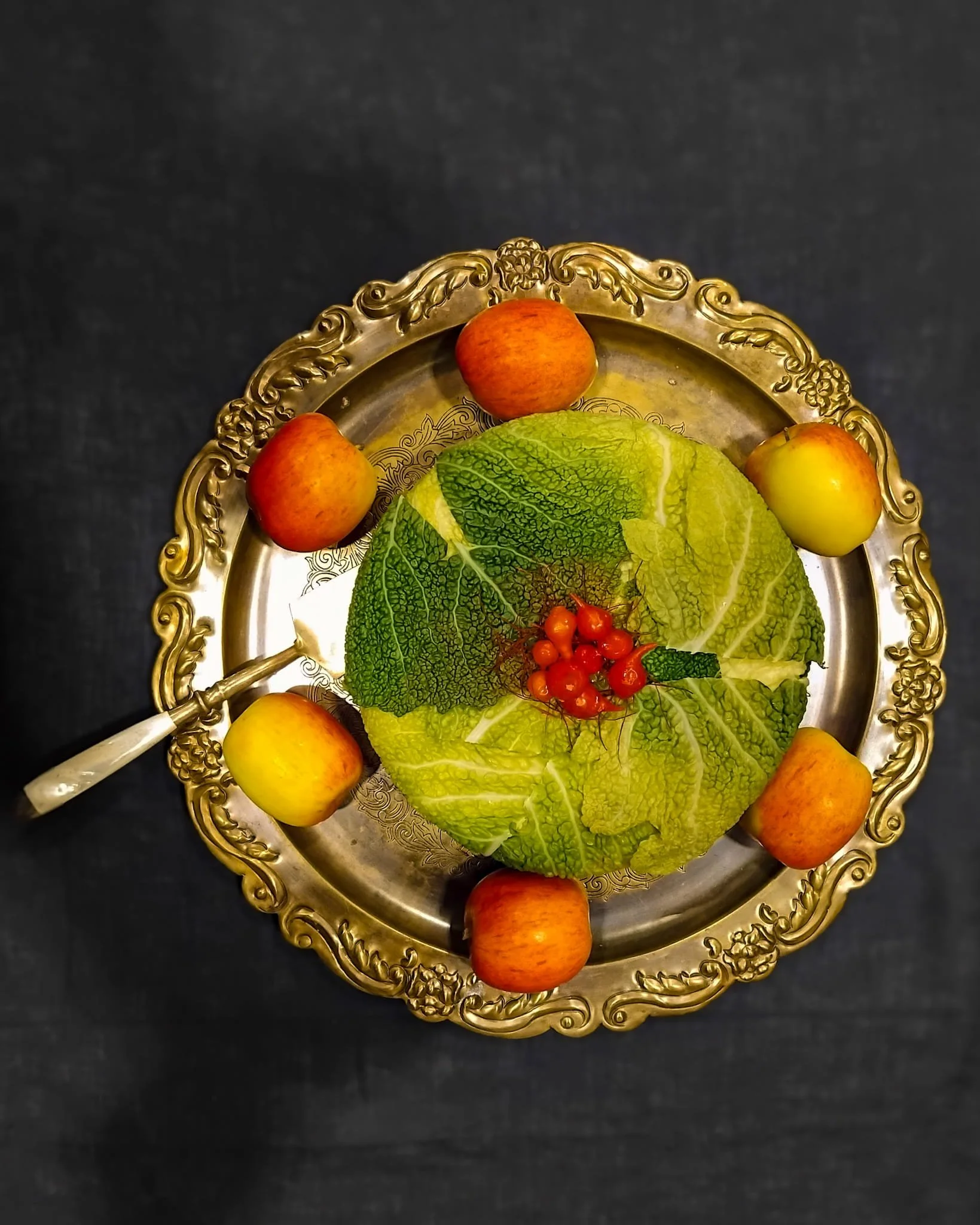 VECETO: Savoy cabbage laid as cladding on a brass tray, apples in a ring. Material exploration.
