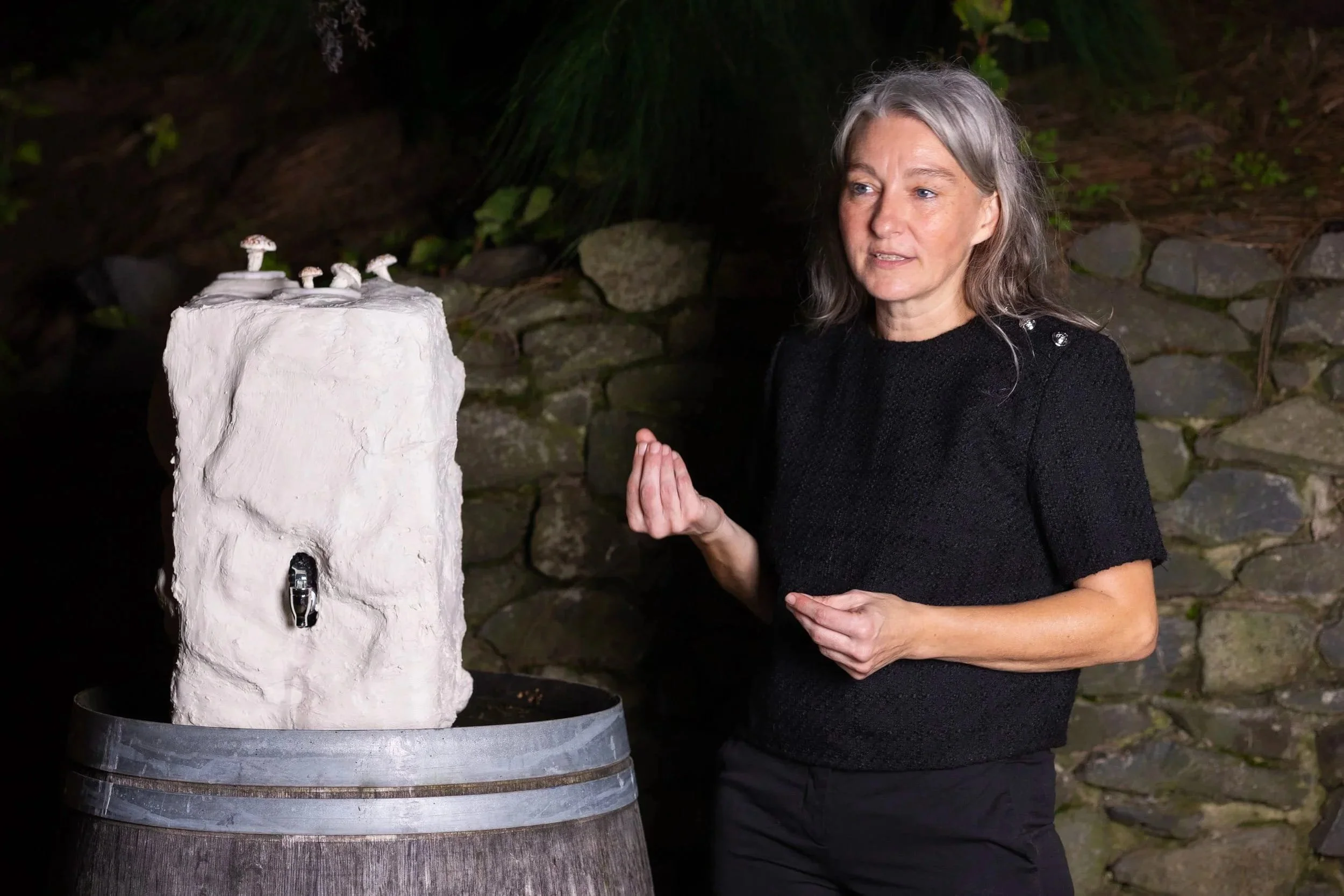 Avant-garde experiential design: Culinary artist Kerstin Pricken beside stone scenography with meringue mushrooms emerging from plaster.