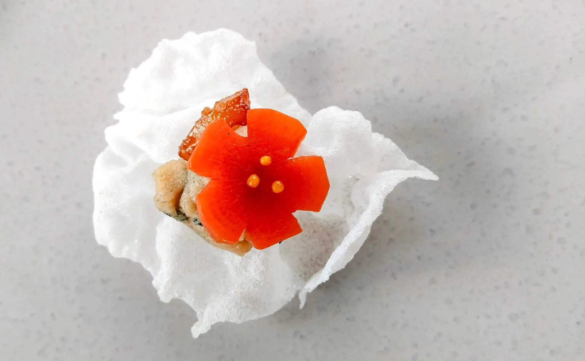 VECETO: Same piece against white marble, the bloom reading alone, everything else pale.