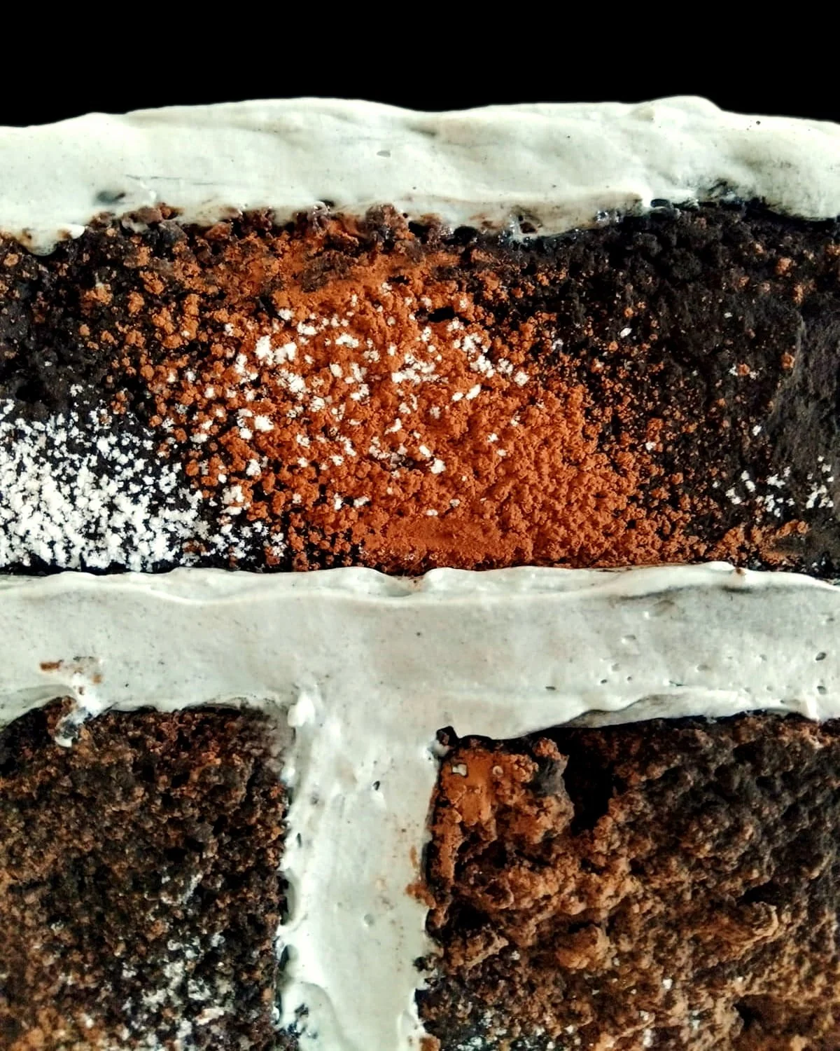 VECETO: Brutalist cake, chocolate brick dusted in cacao. Pale grey mortar joints between dark courses.