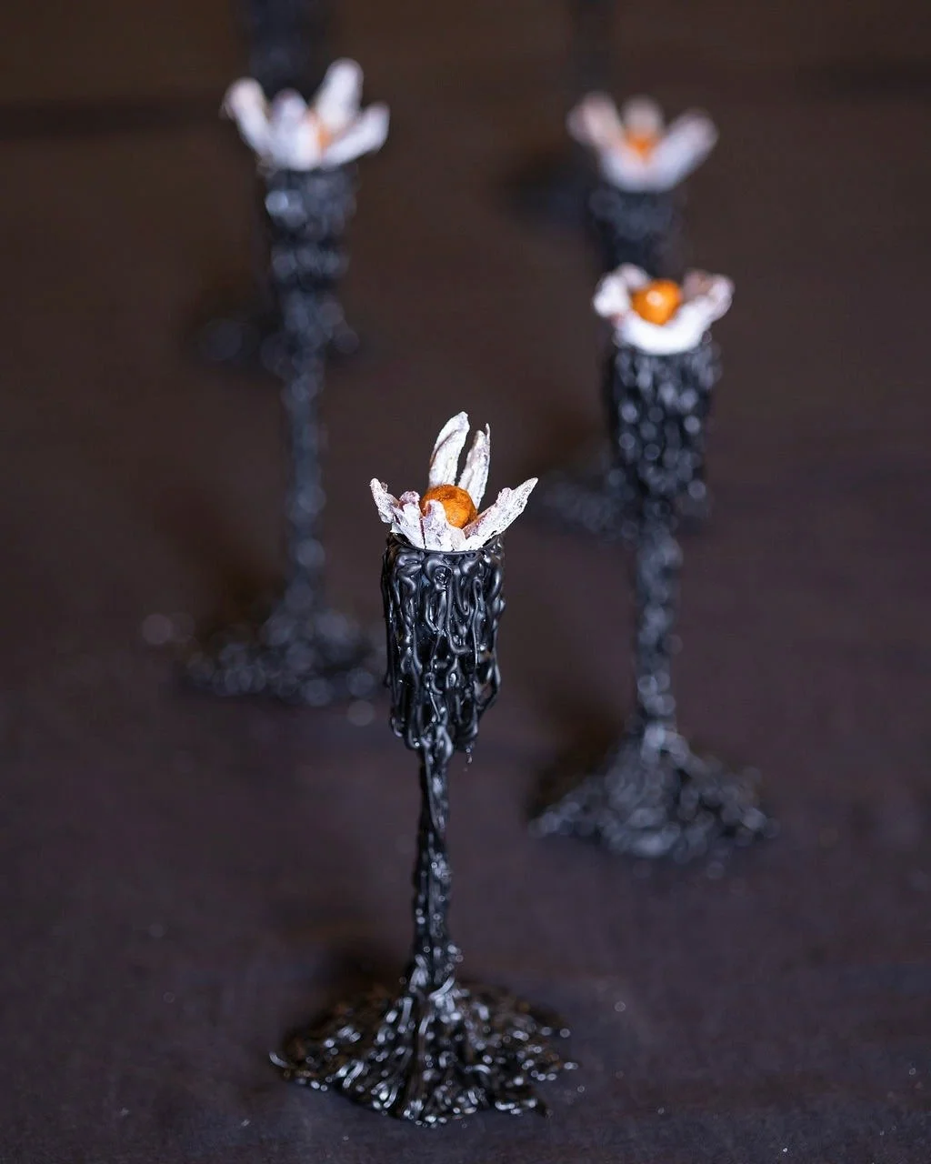 VECETO: Sculptural food installation, candle holders and date flowers on black linen. Neoclassical order in orange and white.