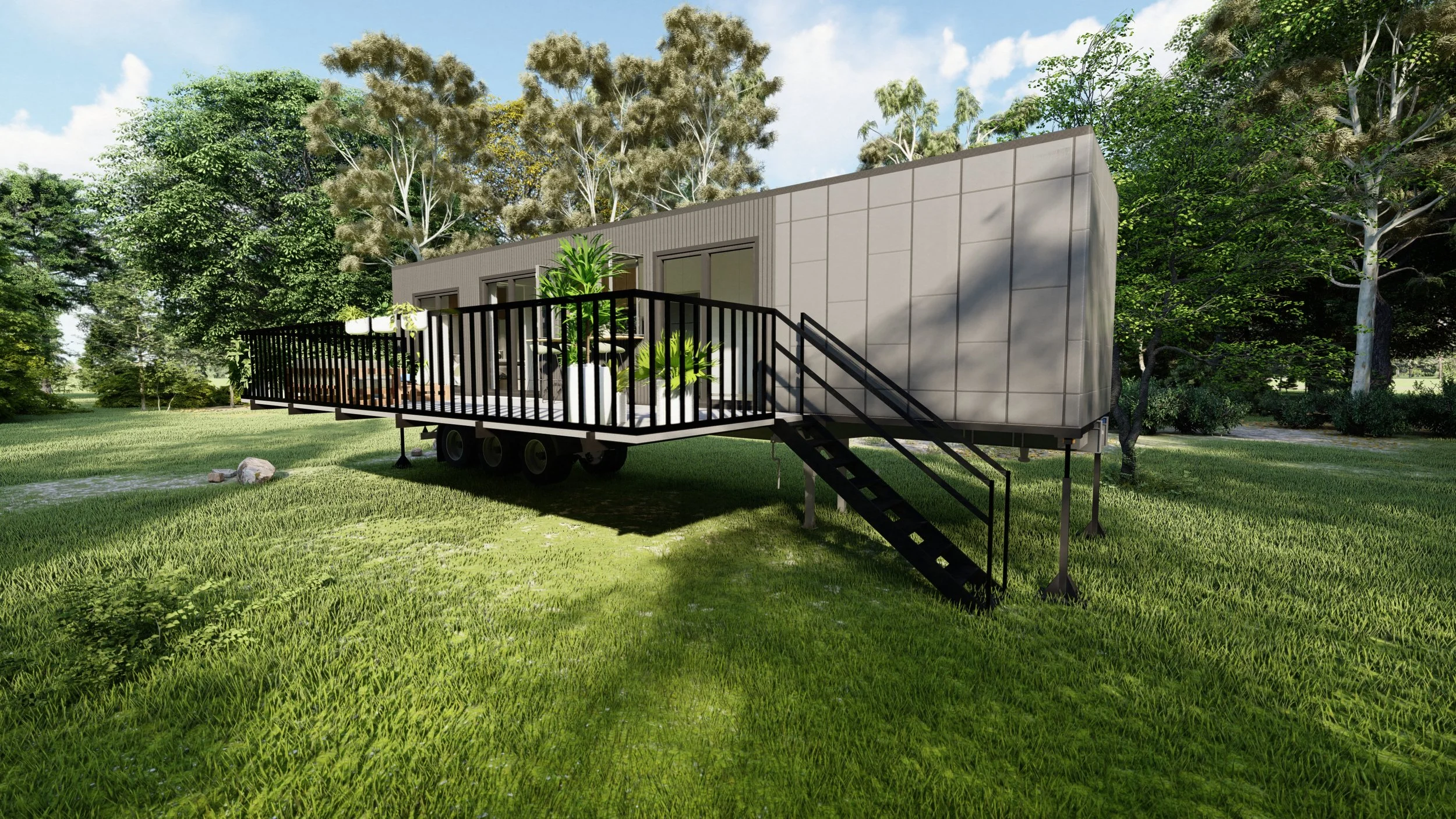 Modern tiny house on wheels with a wooden deck and ramp, surrounded by green grass and trees.