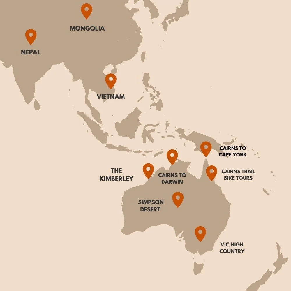 Map showing global motorcycle tour destinations across Australia and Asia including Cairns to Cape York, Cairns to Darwin, Kimberley, Simpson Desert, Victorian High Country, Vietnam, Nepal and Mongolia for guided adventure motorcycle trips