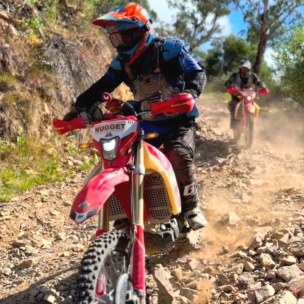 Off-road riders navigating steep rocky terrain in the Victorian High Country on a guided dirt bike tour