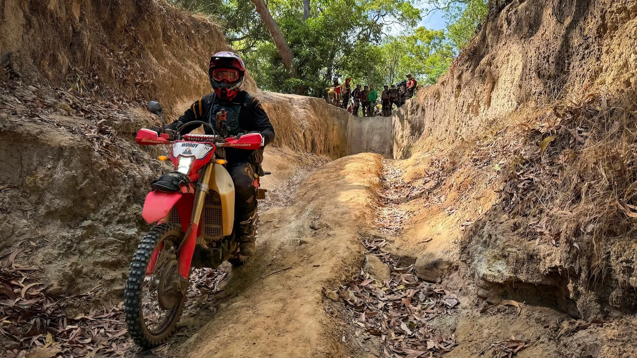 Off-road rider navigating a steep rut on the Old Telegraph Track during a guided Cape York dirt bike tour in Australia