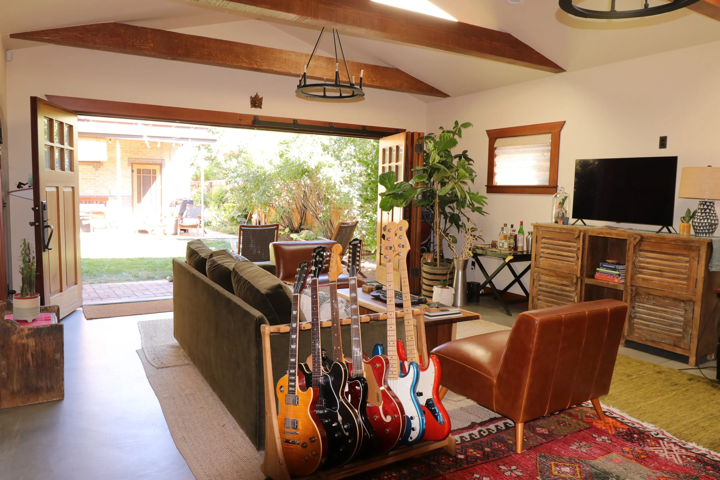 Globally inspired living space with guitars, leather seating and collected vintage pieces