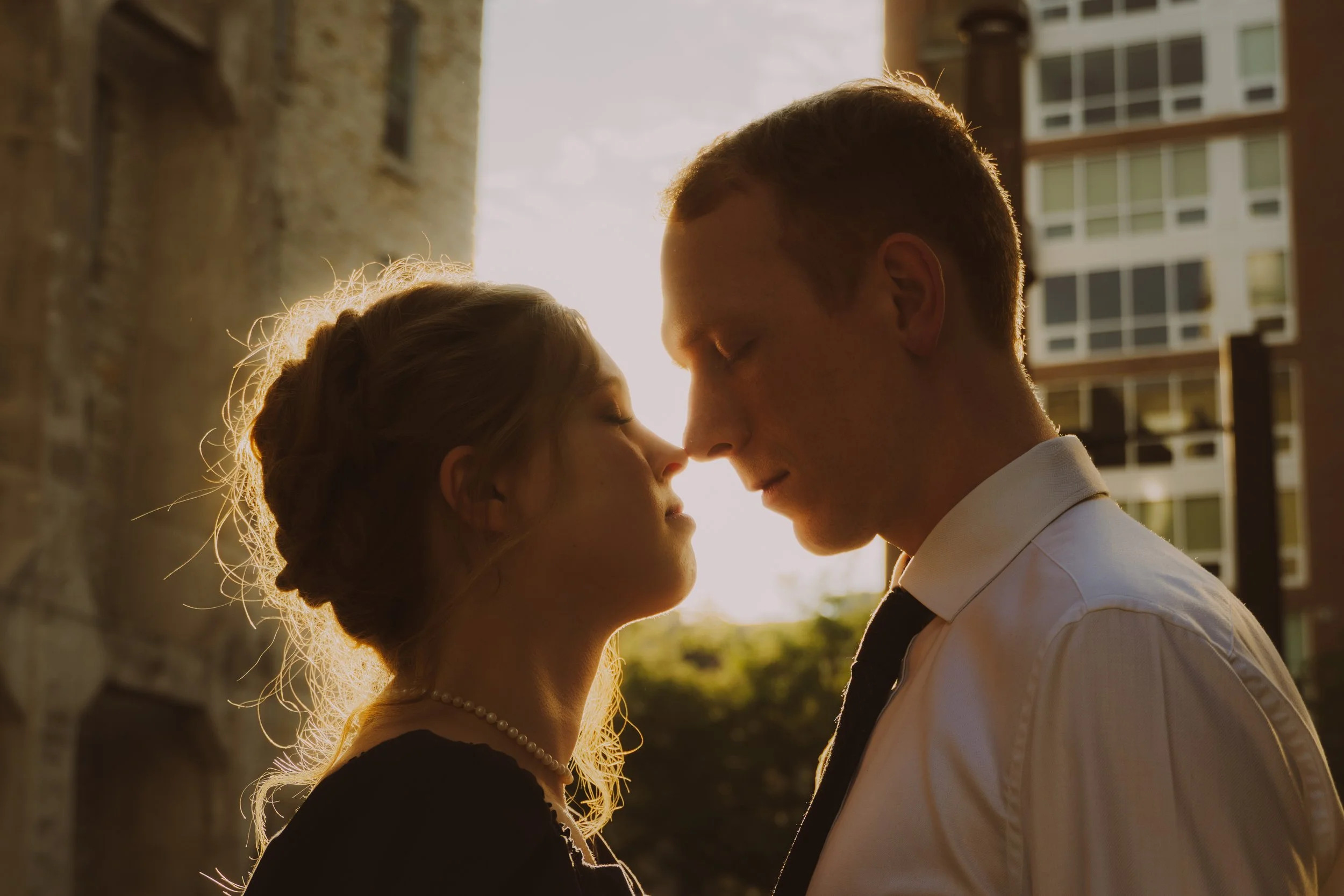 Engagement portrait at St. Anthony Main, Minneapolis, golden‑hour light.