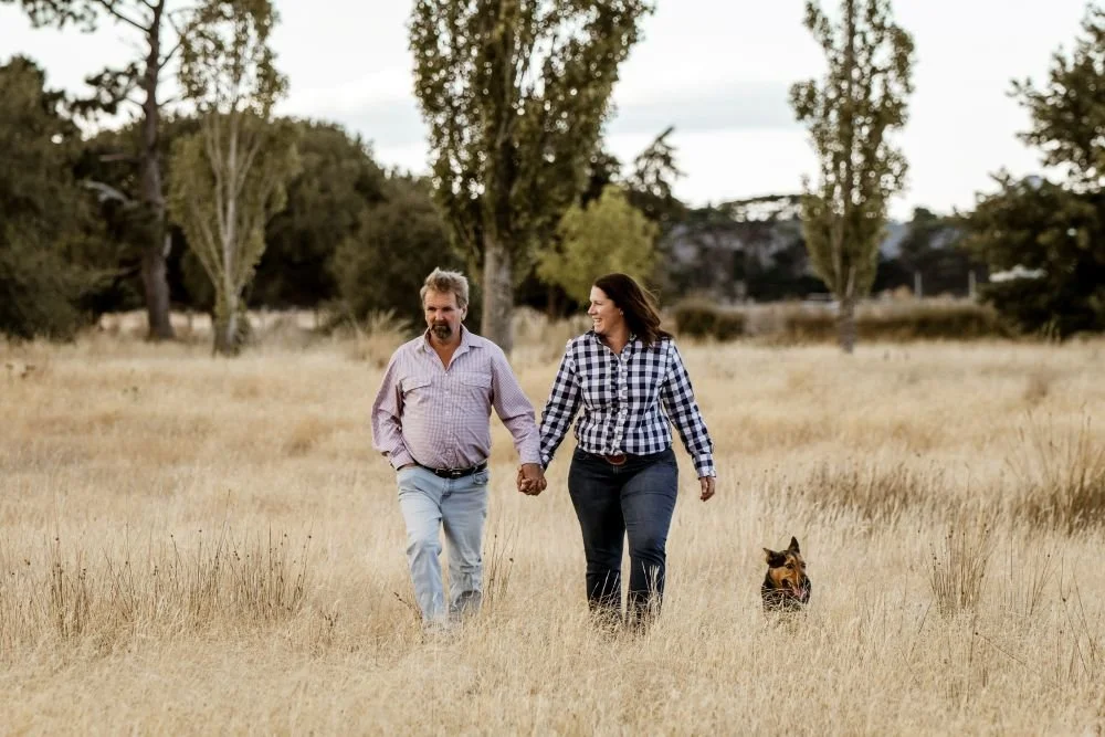 photo of a couple with their dog in a paddock on their farm in Cressy Tasmania captured by local photographer Amy Lyon