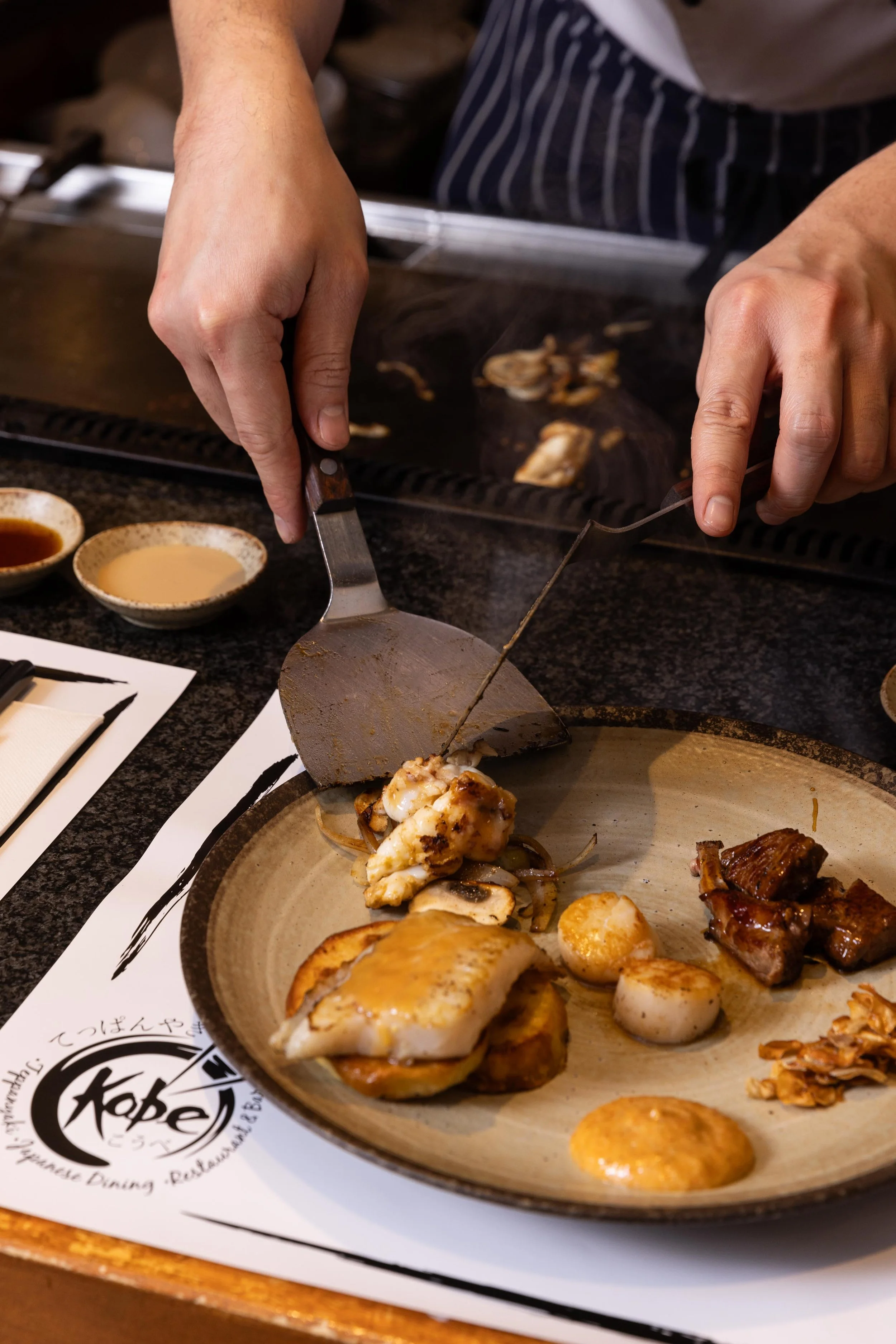 Family friendly restaurant Doncaster East - Teppanyaki Chef places food from grill to plate