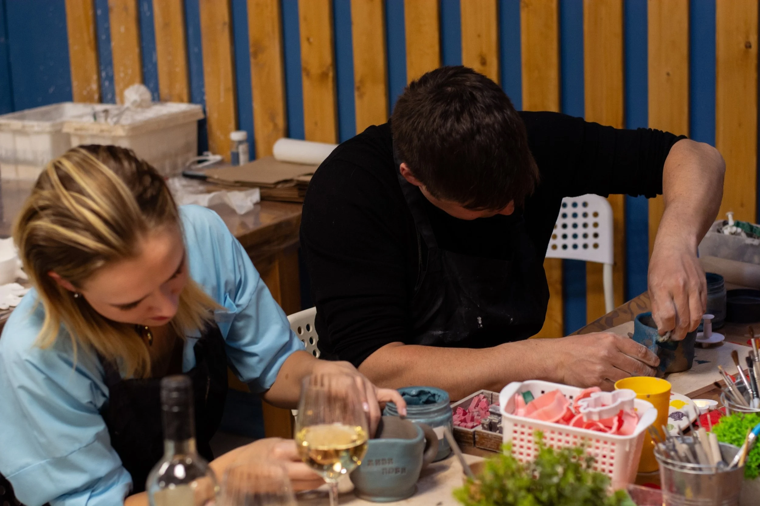 Pottery classes Junius Heights hands molding clay into bowls  