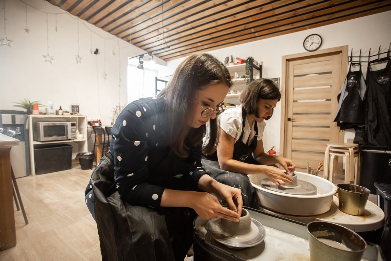 Pottery classes Munger Place group lesson with instructor guiding students 